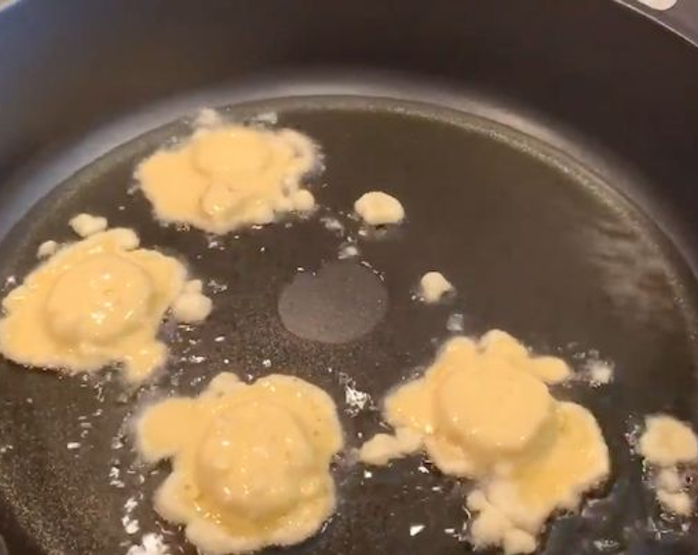 step 6 Place back on the stove and add Corn Oil (as needed) to cover the bottom of the skillet. Heat on medium-high. Add a few of the boiled eggplant rounds to the batter and fry in batches, turning until they are nice and golden on both sides.