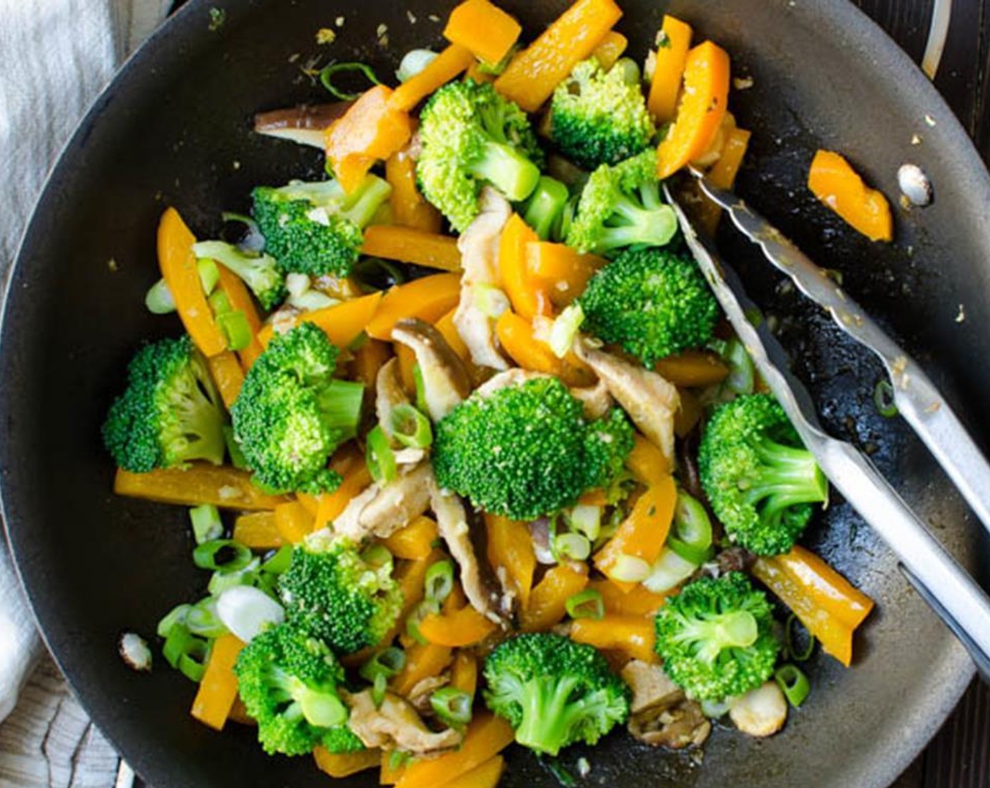 step 7 In a large skillet (with a lid) over medium high heat, add Sesame Oil (1 Tbsp). When pan is hot, add the Red Bell Peppers (2), Shiitake Mushrooms (2 1/3 cups), Broccoli Florets (3 cups) and cook for 1-2 minutes, shaking the pan occasionally.