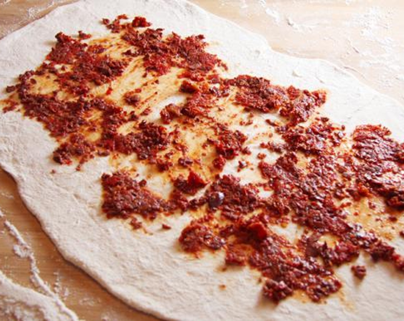 step 3 Lightly flour a work surface and rolling pin. Roll Pizza Dough (1 lb) into a 14x10-inch rectangle. Spread with olive mixture, leaving a 1-inch border around the dough edges on all sides.