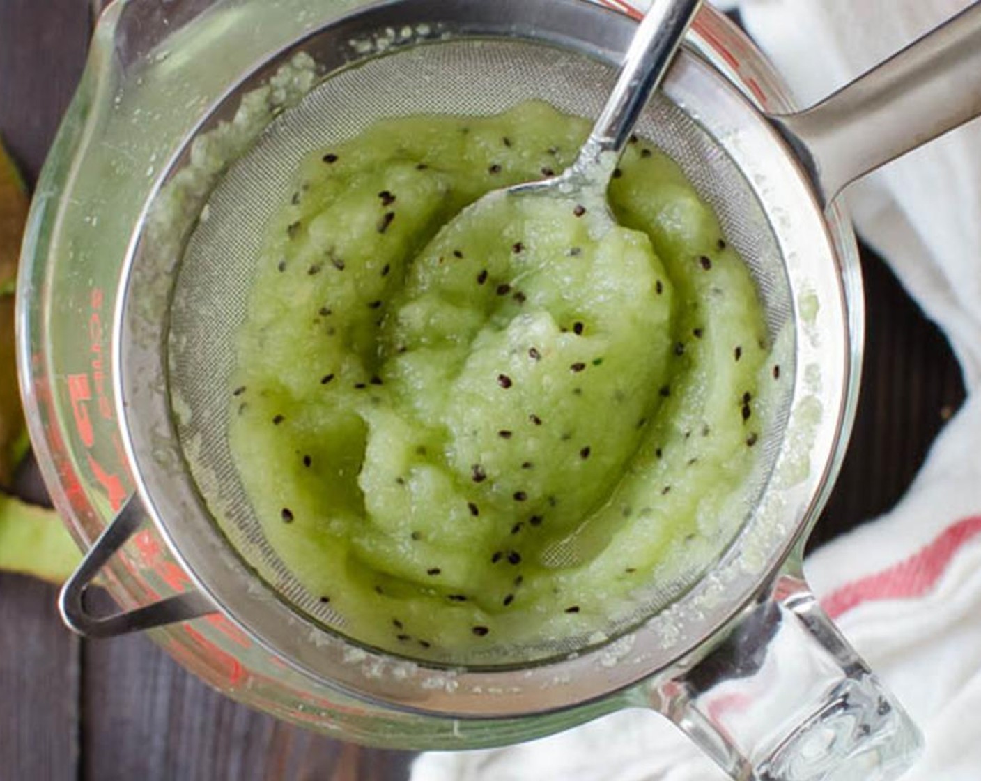 step 5 Place a fine mesh sieve over a glass measuring cup or bowl and pour the cucumber mixture through the sieve. Use a spoon to mash down on the solids to extract every bit of juice from the pulp. Cover and chill.