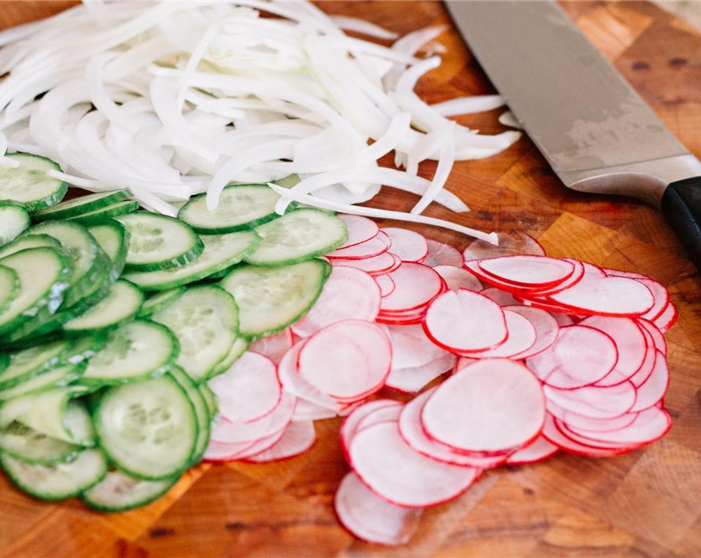 step 8 Use a mandolin to thinly slice the radishes, cucumber, and Sweet Onion (1/2). Set aside on paper towels to drain.