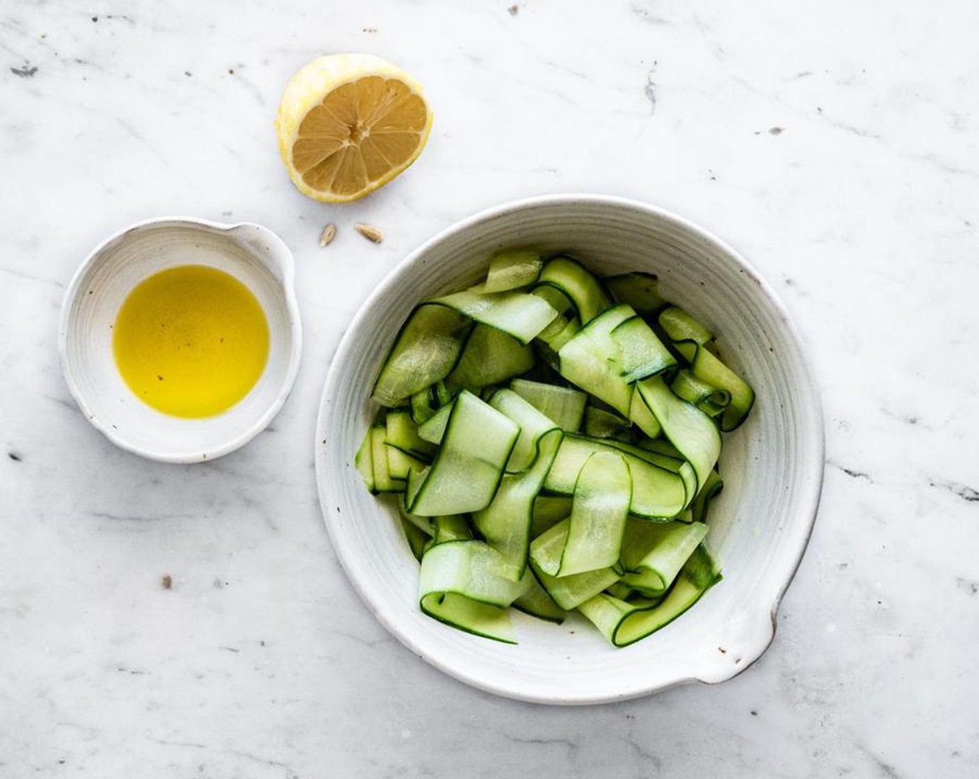 step 2 Add shaved cucumber to a bowl along with the Olive Oil (1 Tbsp) and juice from Lemon (1) - toss to combine and then refrigerate until ready to serve.