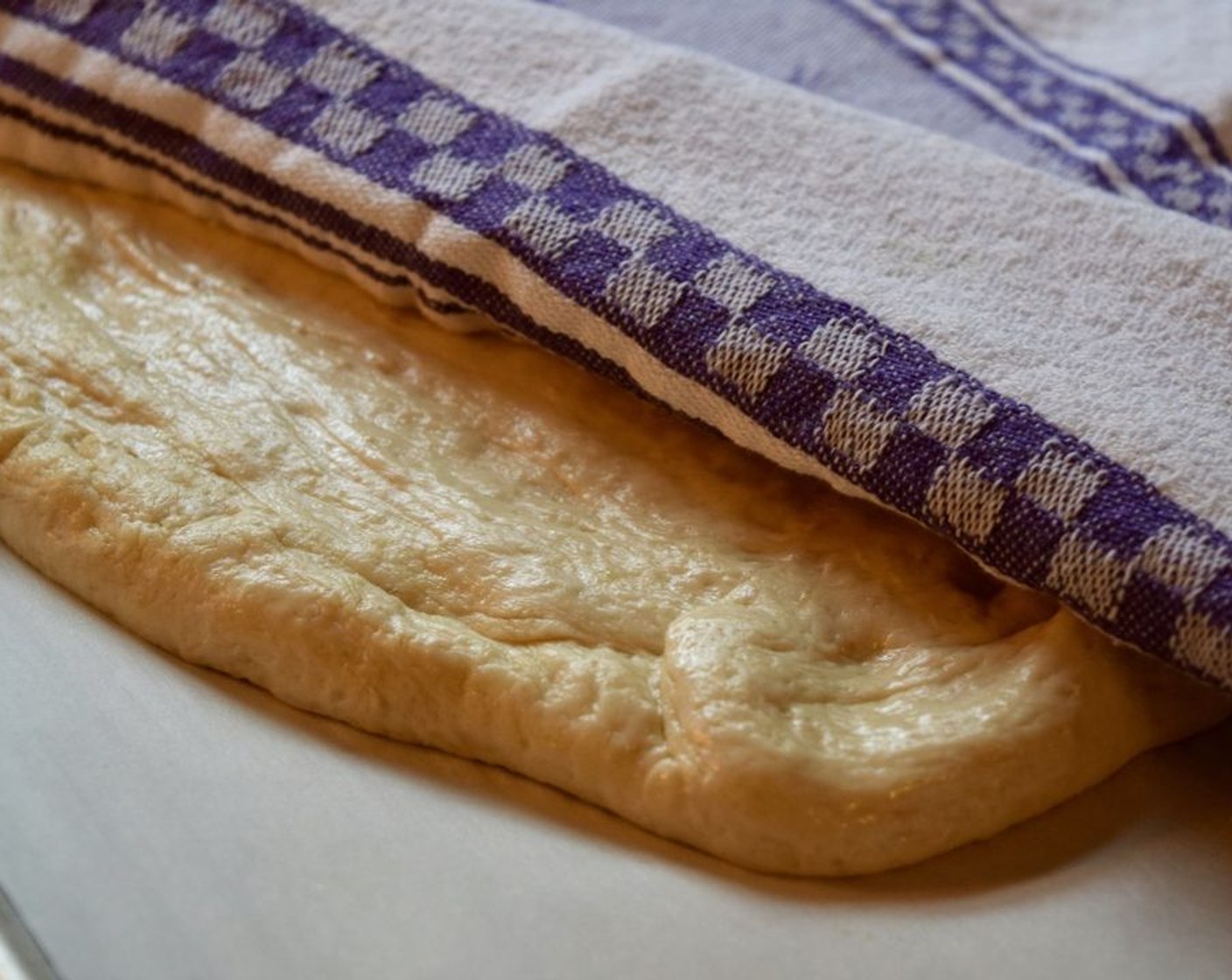 step 8 Place on a parchment lined baking sheet and spread the dough until it is in 1-inch thickness. Cover with a tea towel and let prove again for 30 minutes.