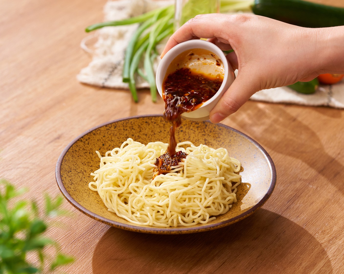 step 4 On a serving plate, toss the noodles in the sauce. Top with bean sprouts, Cucumber (1), Carrot (1/2), Scallion (1 stalk), and Toasted White Sesame Seeds (1 Tbsp). Serve!