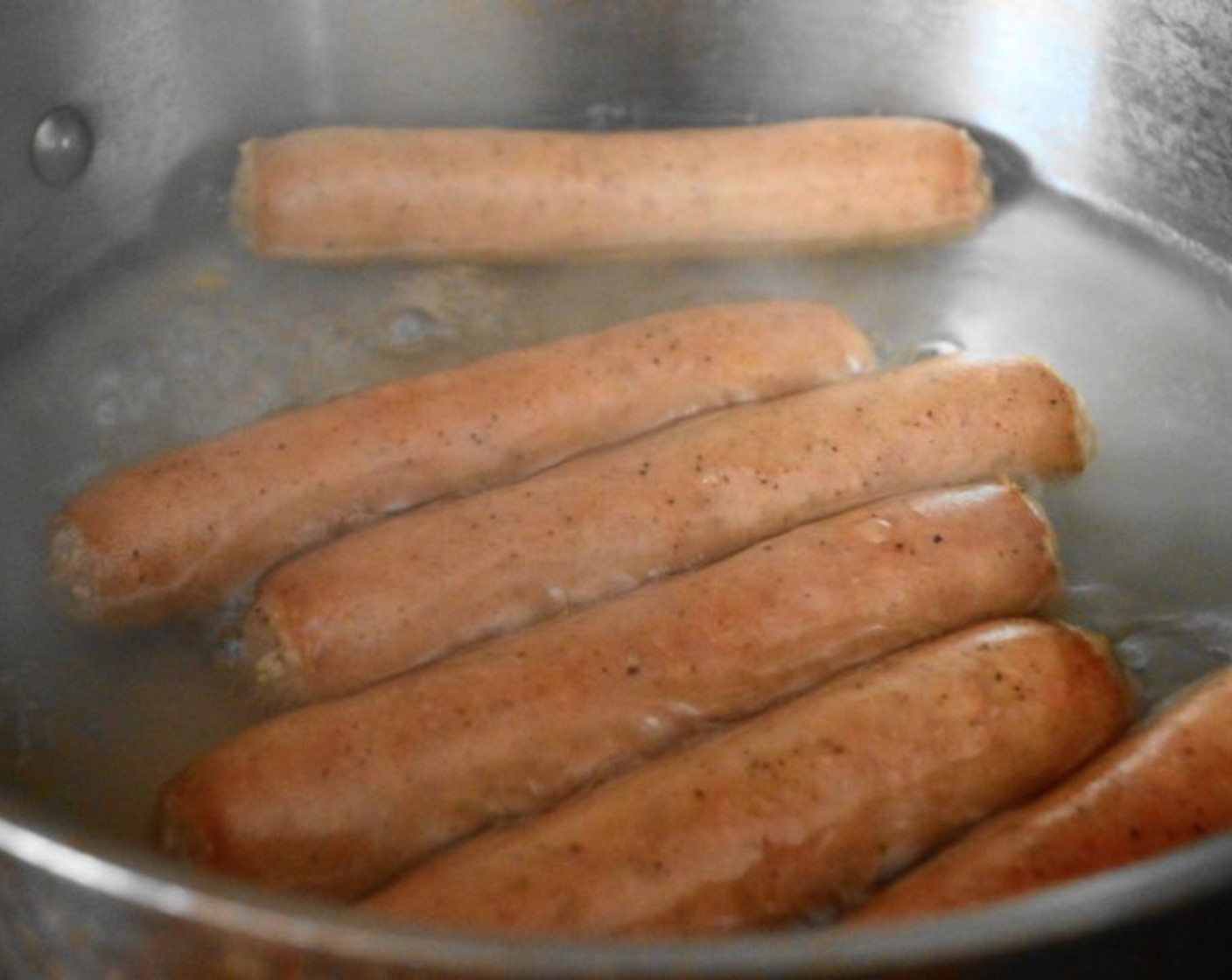 step 1 Fill a large pan with 3-inches of water and bring it to a boil on the stove. Boil the Bratwurst (6) for about 15 minutes to let them plump up and cook through.