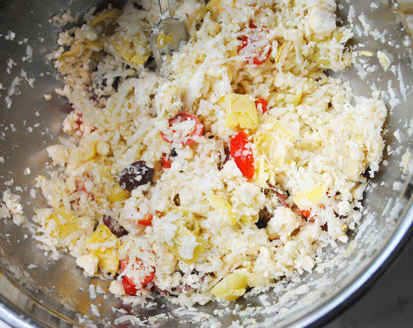 step 1 Place the Cauliflower (1 head) into a bowl and mix it with the Grape Tomatoes (1/3 cup), Kalamata Olives (4 Tbsp), Feta Cheese (4 Tbsp), Artichoke Hearts (4), and Greek Seasoning (2 tsp).