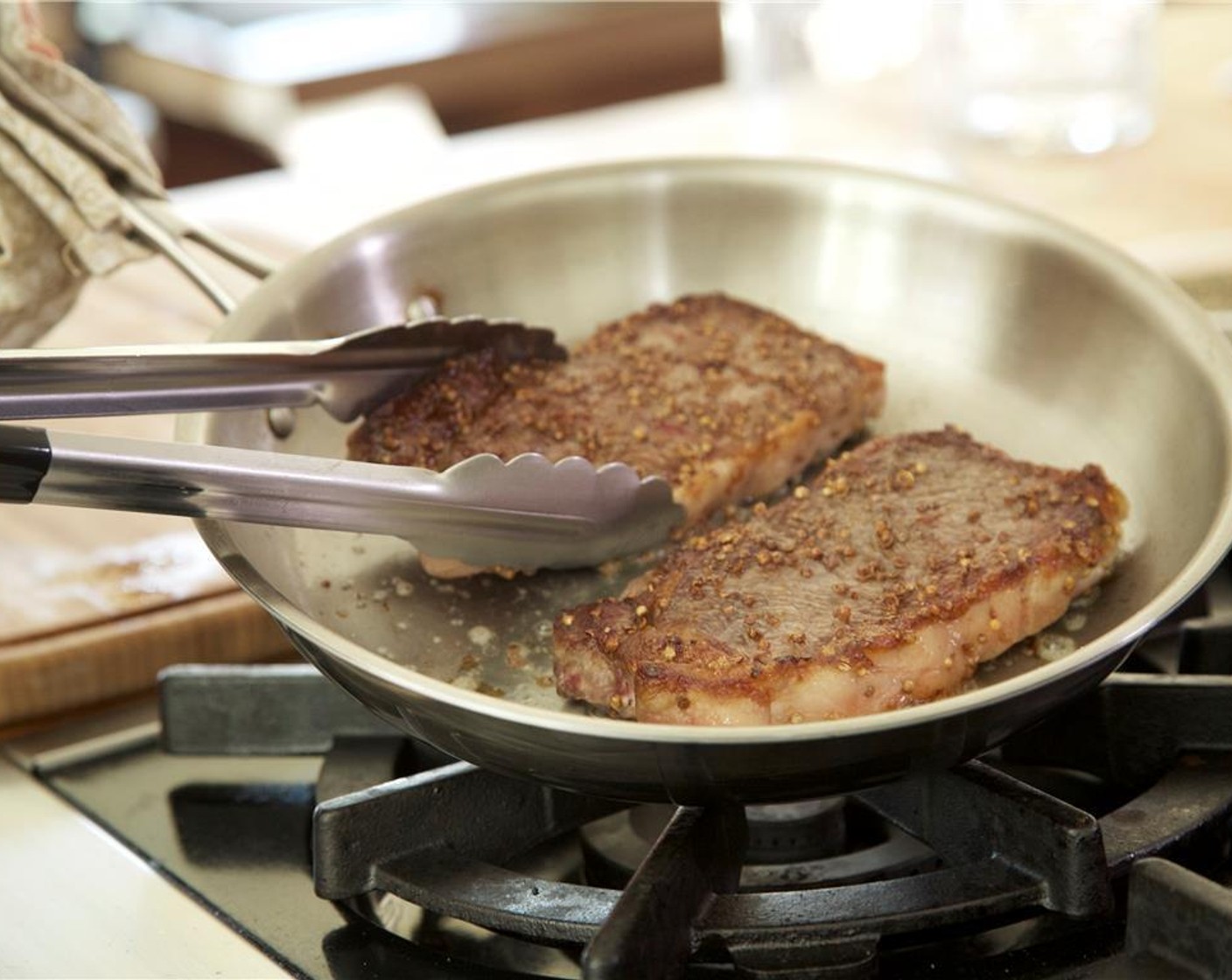 step 8 Heat a medium saute pan over high heat. Add a pat of Butter (to taste) and 1 tablespoon olive oil. When hot, add the steaks and sear for 2 minutes. Turn over and sear for 2 minutes more. Let rest until plating.
