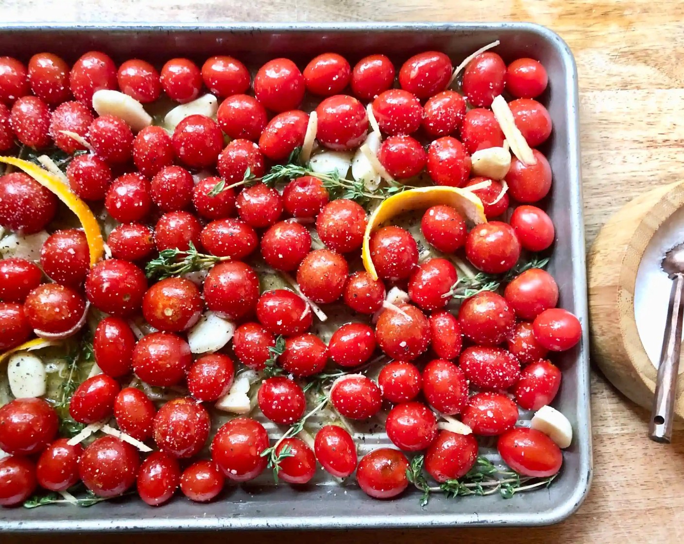 step 2 Arrange the Cherry Tomatoes (4 cups) in a single layer on a 13x9-inch baking pan or dish. Place the 3 pieces of Oranges (3) and Fresh Thyme (3 sprigs) within the tomatoes so that they are evenly spaced throughout the pan.