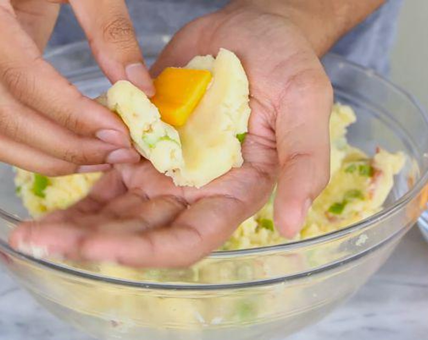 step 3 Using your hands, take a bit of the mixture and form it into a patty. Press a piece of the Cheddar Cheese (to taste) in the center and roll the mashed potato into a ball around it. Repeat with the rest of the mixture. Chill in the fridge for 20-30 minutes.