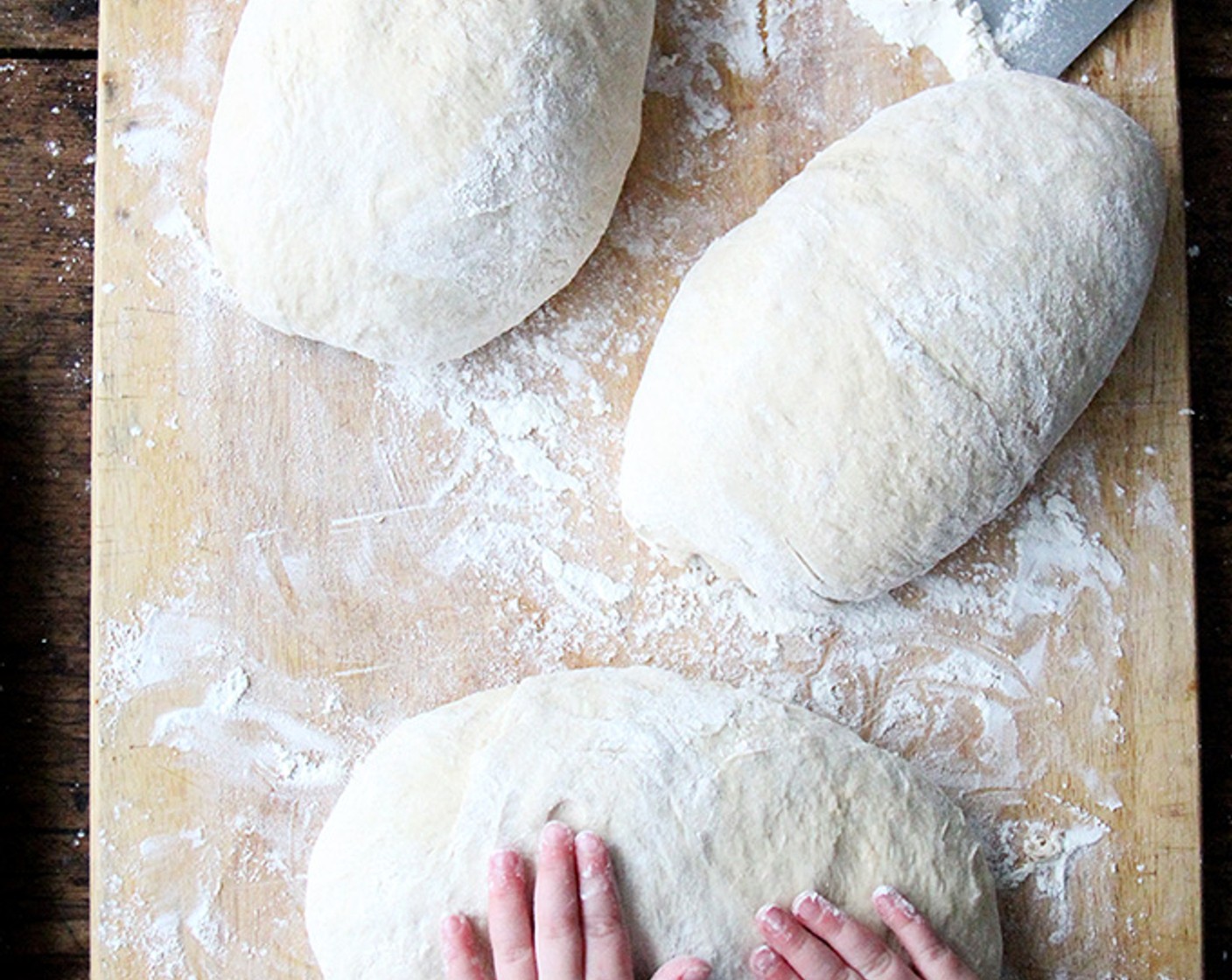 step 8 Using as much flour as necessary from the surface, dust your hands and the exterior of the dough, then shape the mass as best you can into a ball and flatten into a rectangle/oval—doesn't have to be perfect.