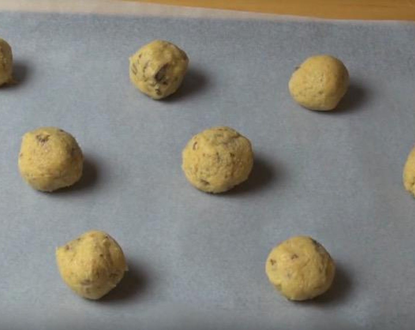 step 4 Roll spoonfuls of the mixture in hand to create small balls. Place on tray lined with non-stick baking paper, leaving a bit of space in between cookies.