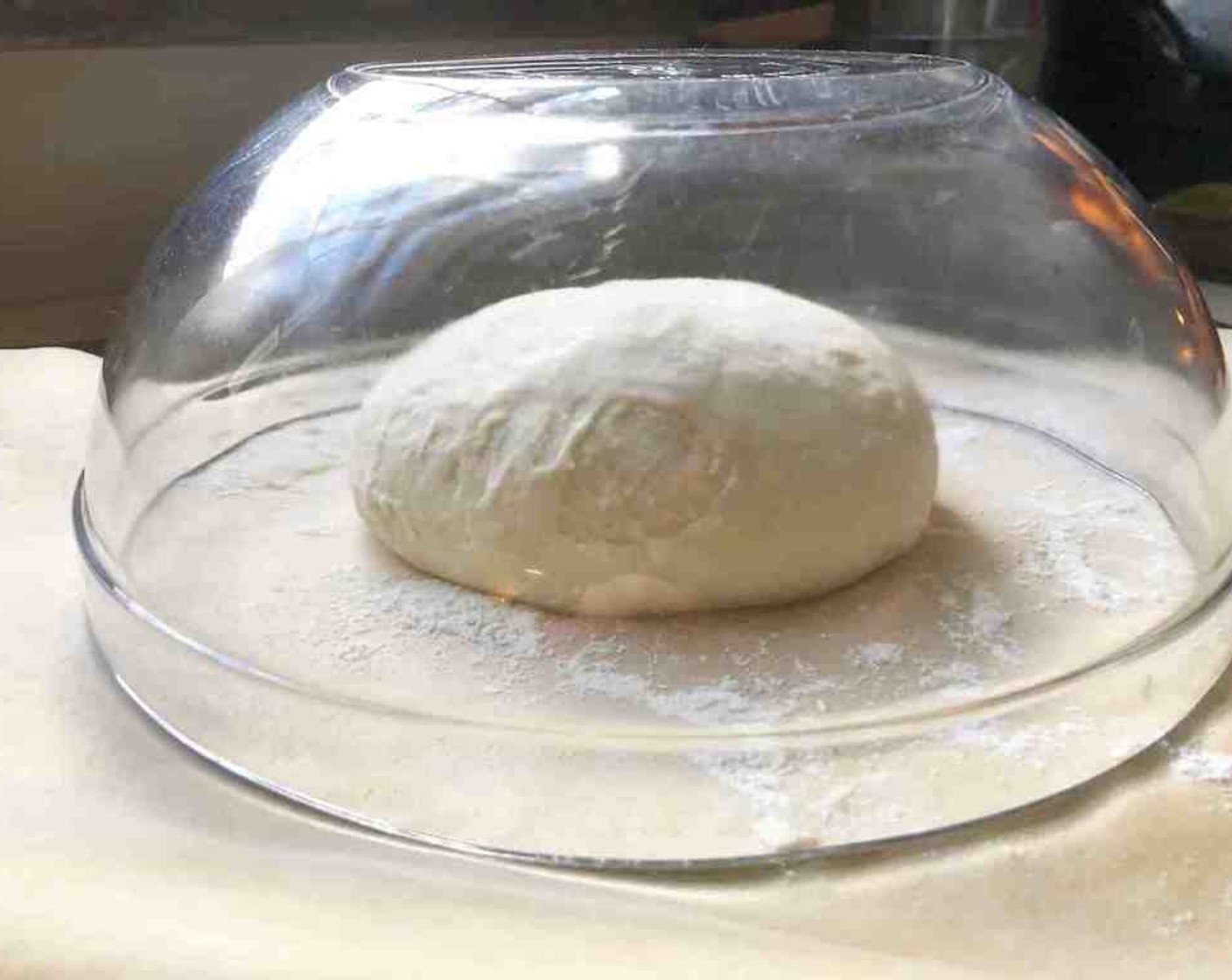 step 11 Place the shaped ball of dough on a pizza peel that’s been covered with a sheet of parchment paper, seam side down with all the collected bunched ends on the peel. Let it rest for about 40 minutes.