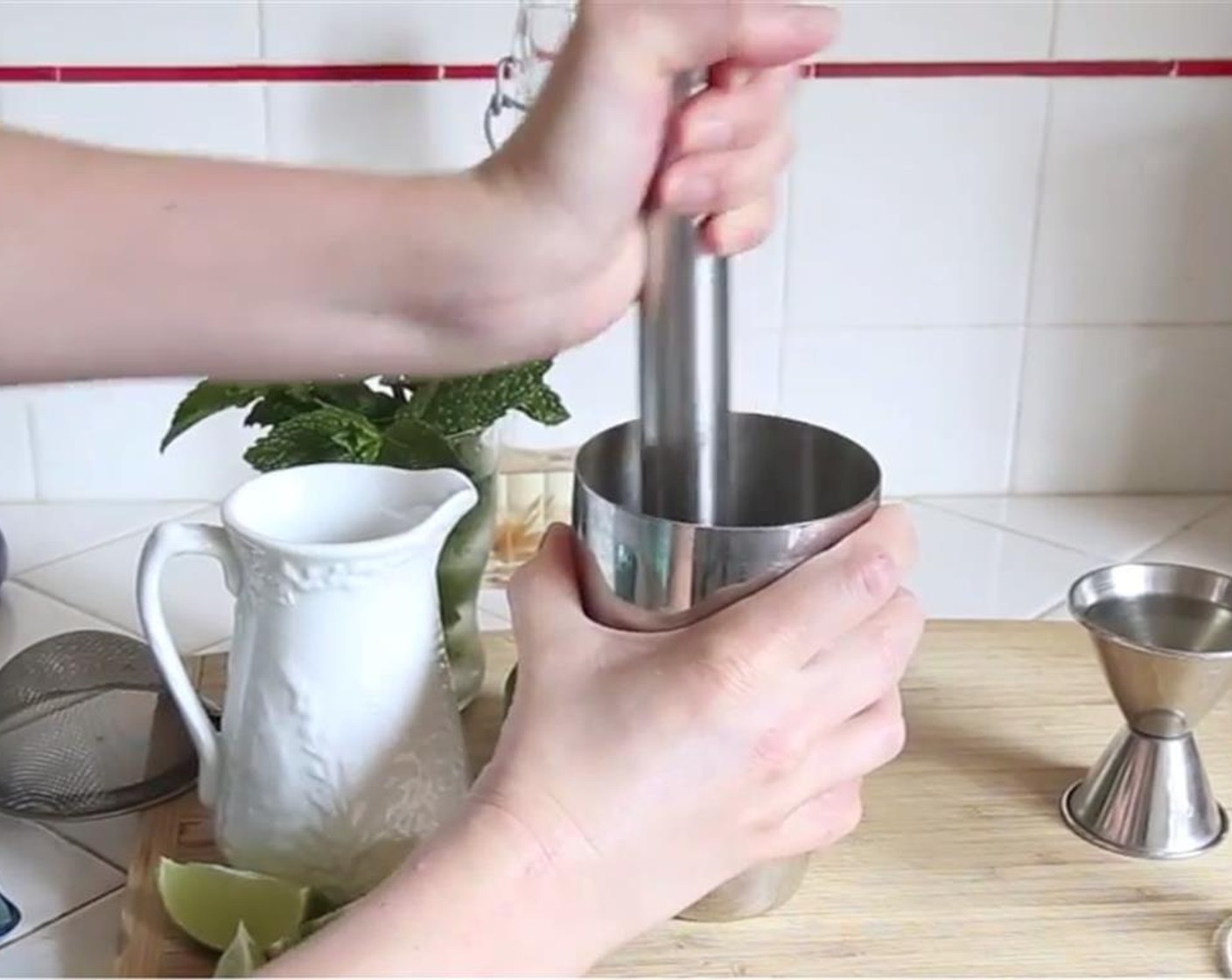 step 6 In a shaker, place 2 lime wedges and Fresh Mint Leaves (to taste). Muddle to release flavors.