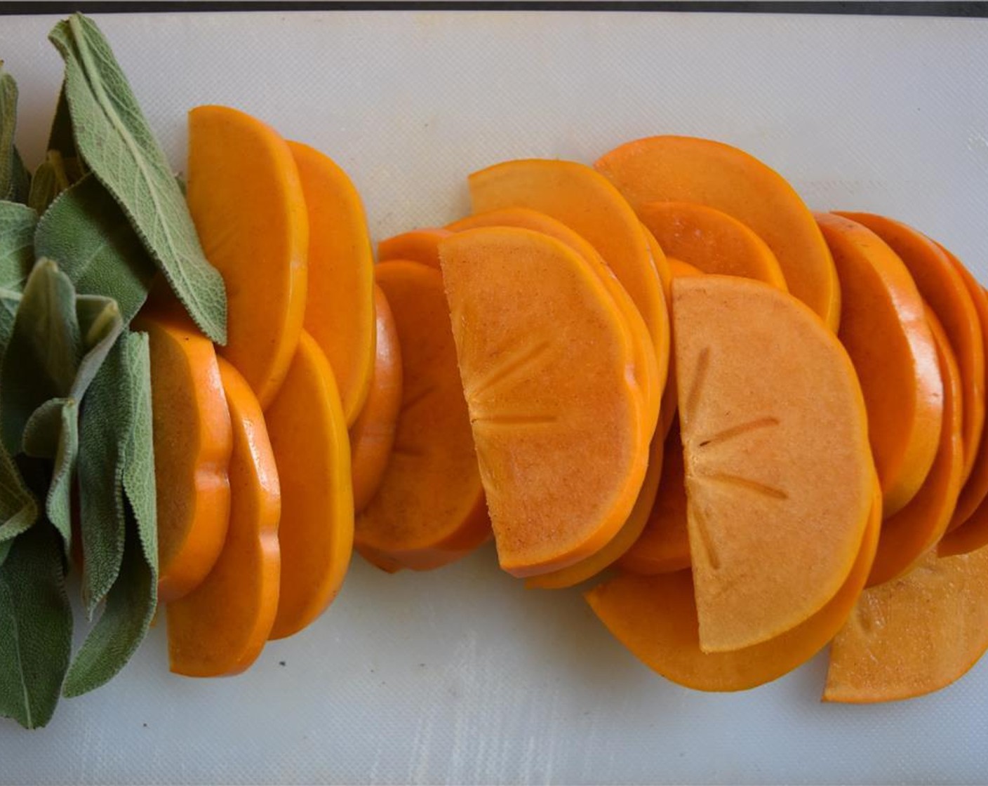 step 4 Thinly slice the Persimmons (2) and gently pull the Fresh Sage (3 sprigs) of the stems.