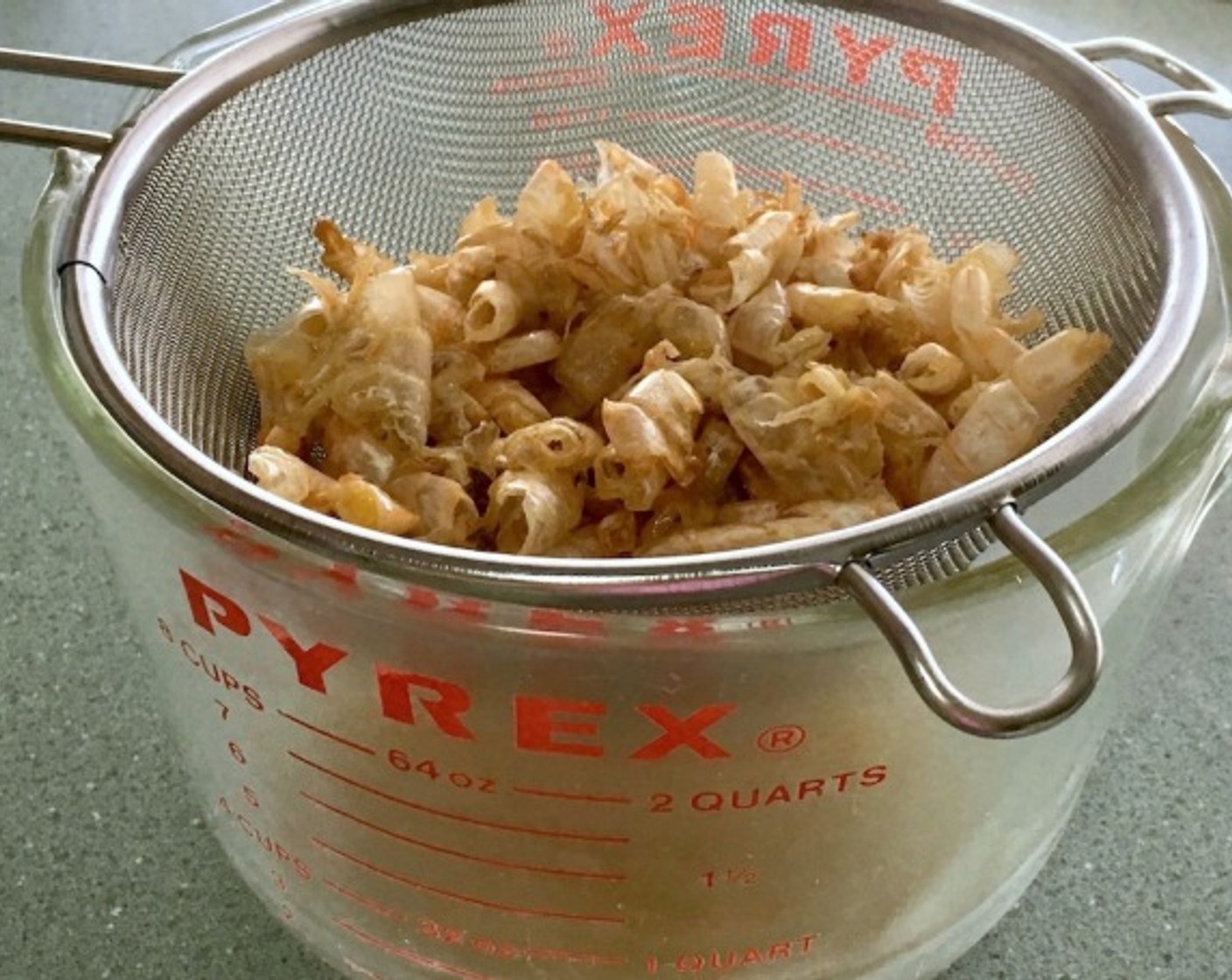 step 4 Strain shells through a sieve, pressing gently on them to extract all liquid into a bowl. Discard the shells.