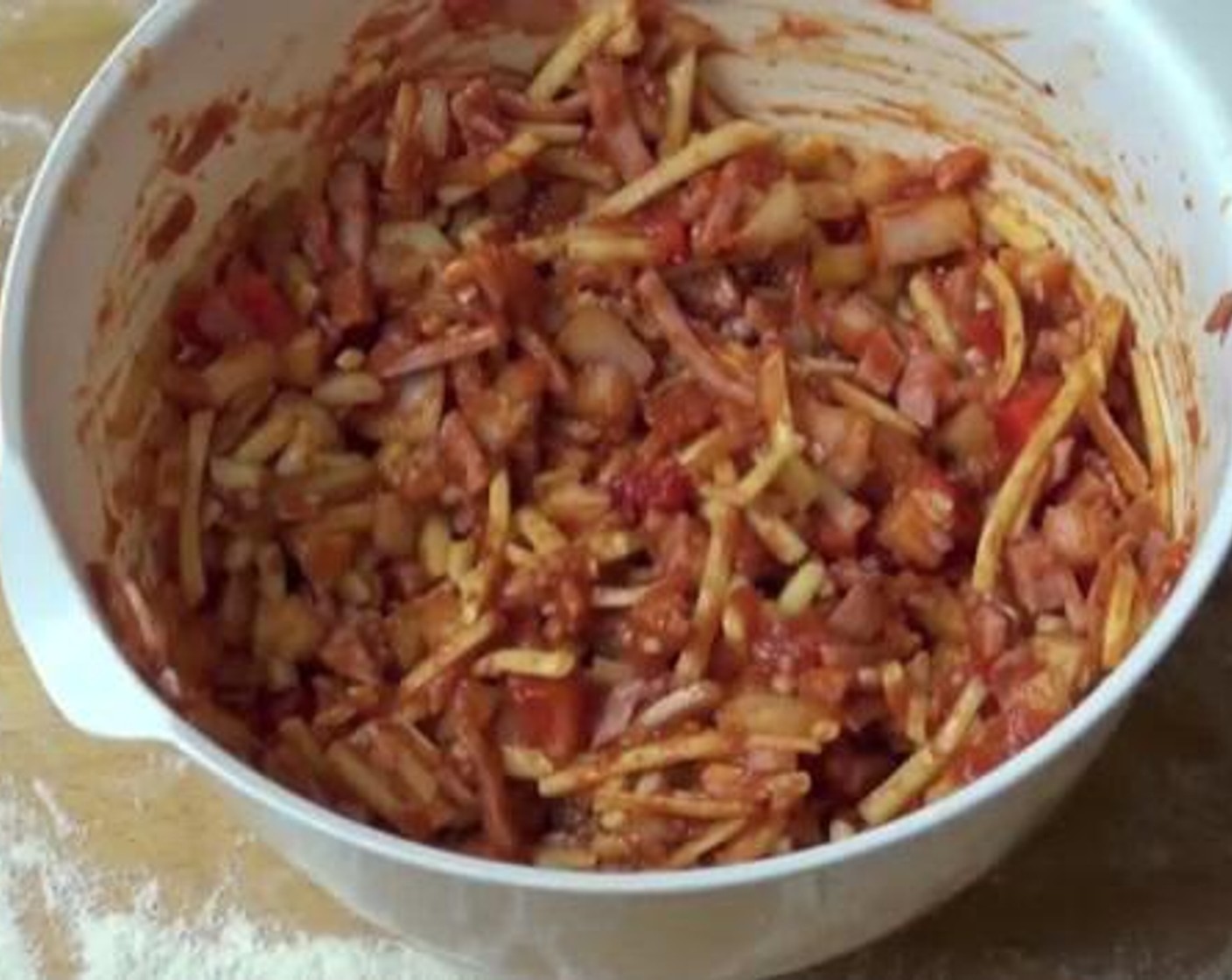 step 2 Add the Ham (1 cup), the chopped Yellow Onion (1), Red Bell Pepper (1/2), Cheddar Cheese (1 cup) and Tomato Sauce (1 1/2 cups) into a mixing bowl. Mix everything all together. Set aside while you prepare the dough.