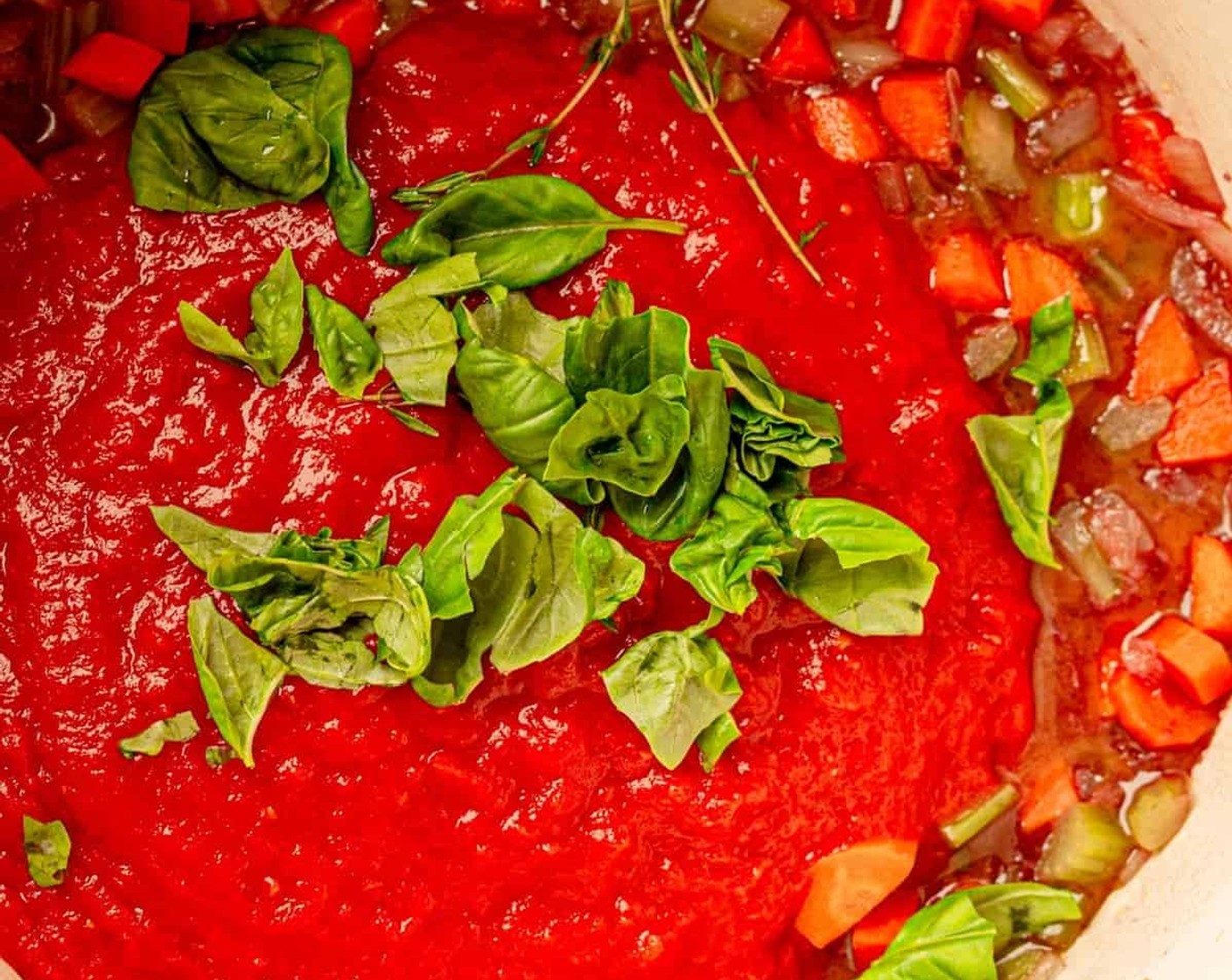 step 5 Next, add Crushed Tomatoes (1 can), Salt (1 tsp), Ground Black Pepper (to taste), Fresh Basil (1/4 cup), and Fresh Thyme (1 sprig).