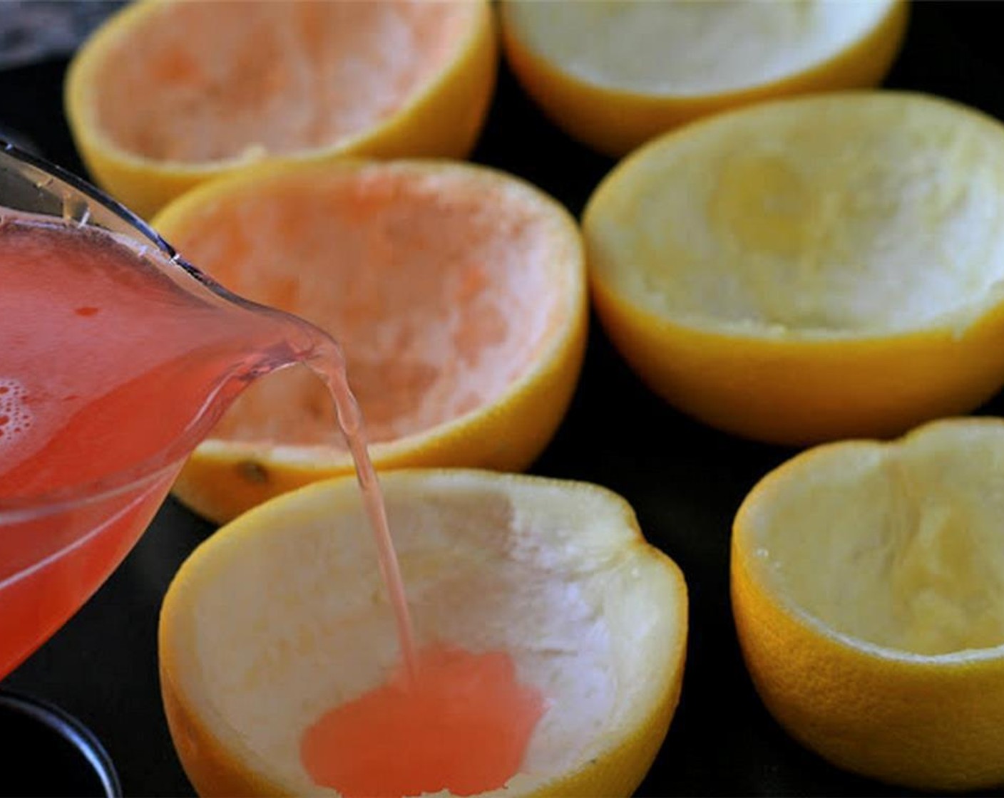step 5 Pour in Grapefruit Vodka (3/4 cup) and Water (4 Tbsp) and transfer to something with a pour spout, such as a measuring cup. Place grapefruit halves in a muffin pan to keep them stabilized and pour in the grapefruit juice mixture.