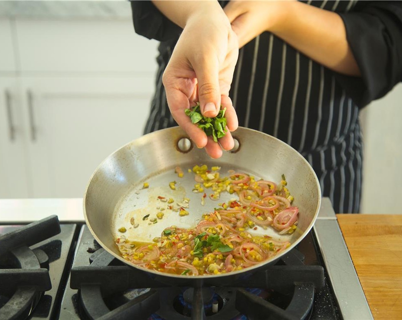 step 17 Heat Olive Oil (1 Tbsp) in a small saute pan over medium. Add the thai chili, garlic cloves, shallots, ginger and saute, stirring frequently for thirty seconds. Then turn the heat to low.