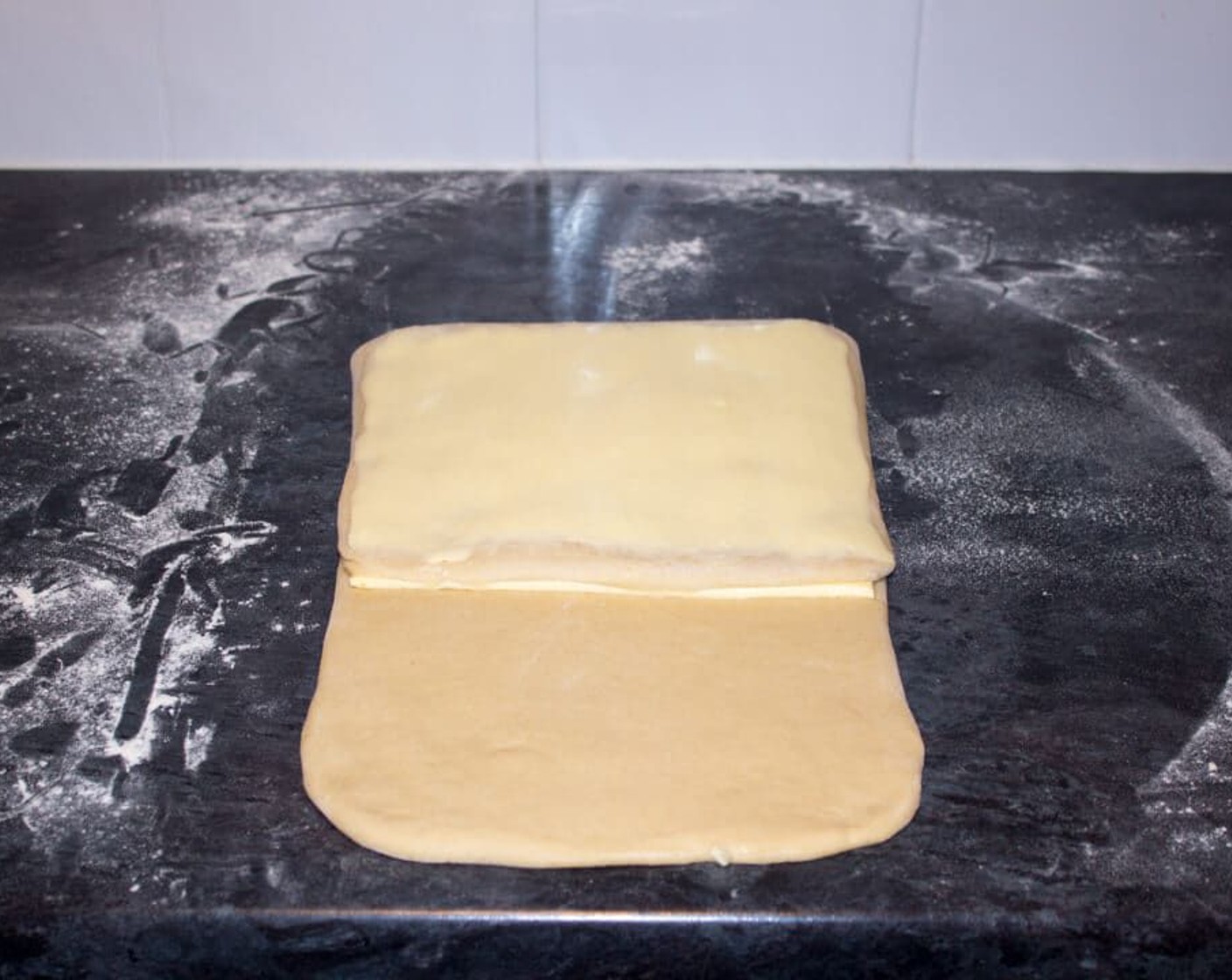 step 9 Then carefully cut the exposed butter off without cutting the dough underneath it, and place on top of the dough you just folded down.