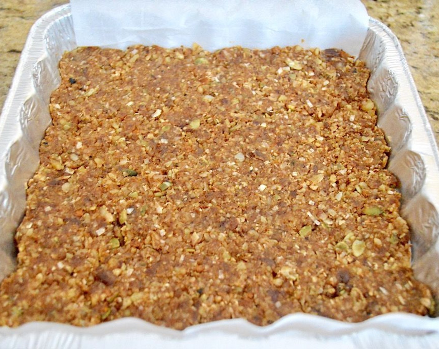 step 3 Line an 8x8-inch pan with parchment, leaving a little hanging over the edge. Press the mixture firmly into the pan so that it sticks together well.