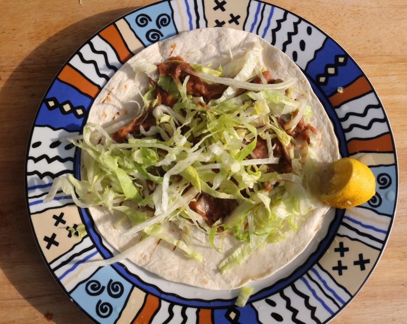 step 6 Top the refried beans with 1/2 cup Lettuce (to taste) and a squeeze of Lemons (to taste).