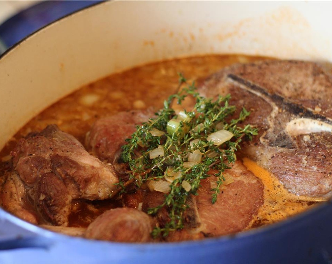 step 11 Return the seared pork shoulder to the pan, and top with thyme. Place it in the oven and cook for 3 hours.
