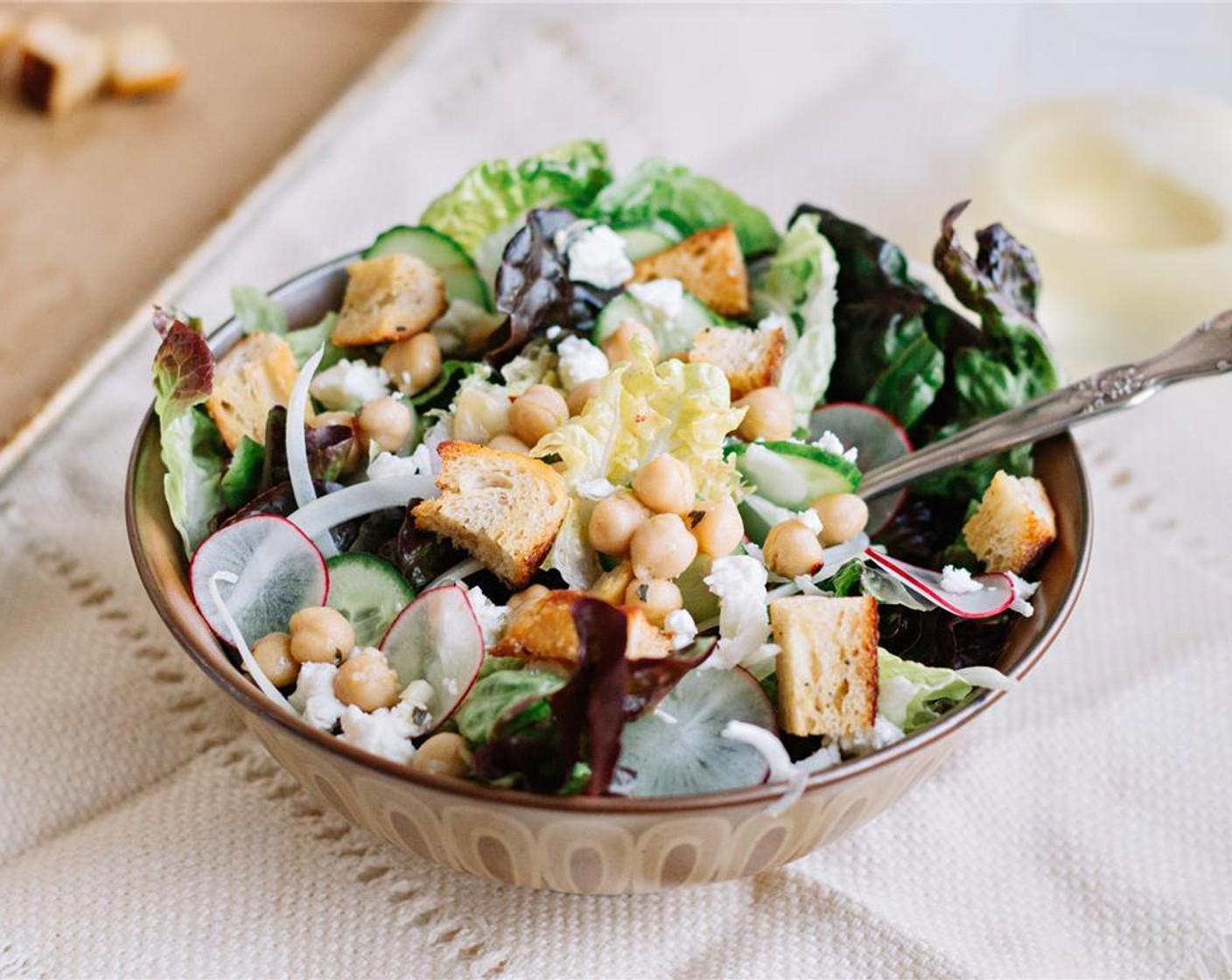 step 10 In a salad bowl, toss the sliced radishes, cucumbers, onions, lettuces, Balsamic Vinegar (2 Tbsp) and Olive Oil (1 Tbsp). Season with salt and pepper to taste. Divide into bowls and top with marinated chickpeas, Crumbled Feta Cheese (1/2 cup) and croutons. Serve and enjoy!