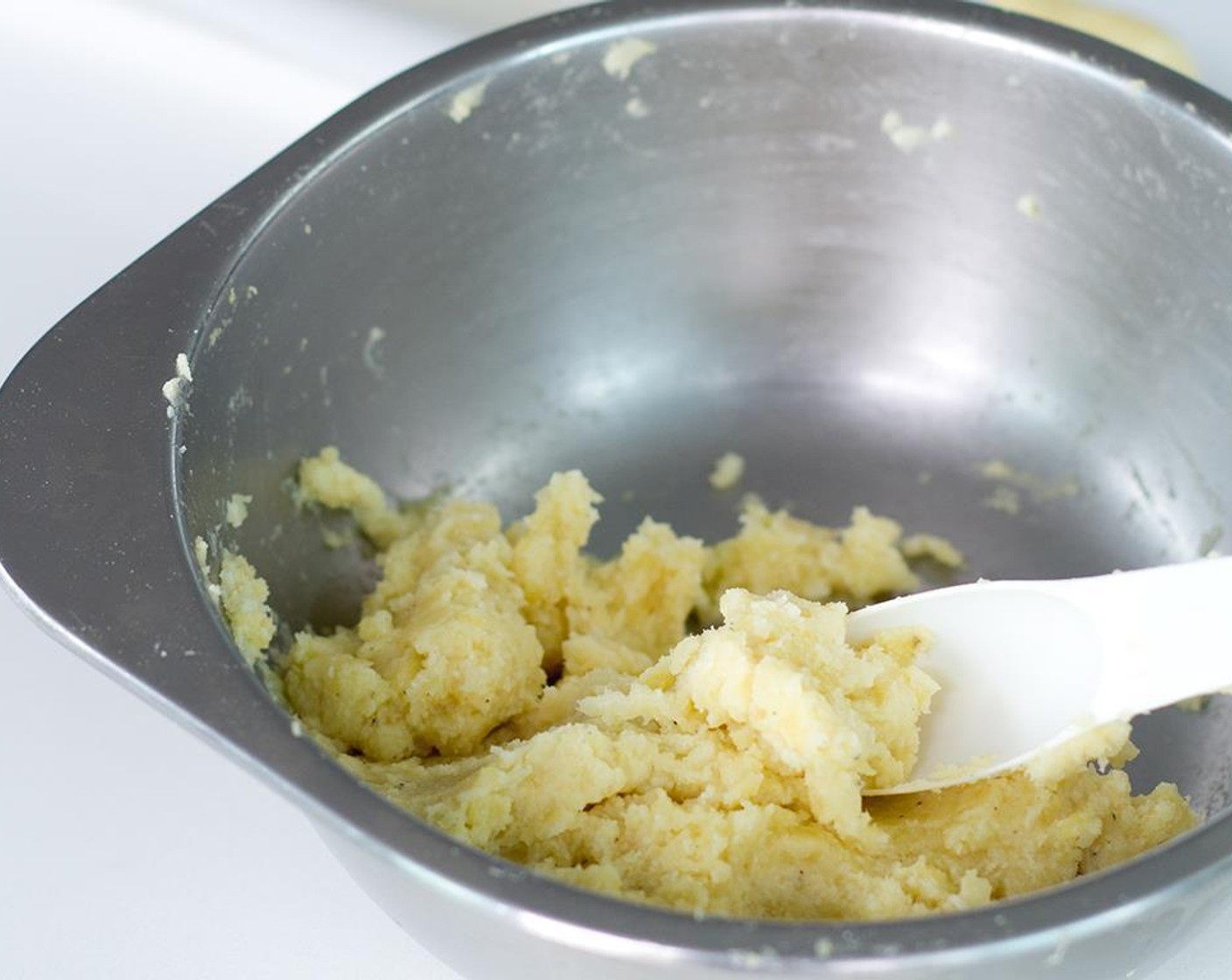 step 4 In a medium sized bowl, take the grated sweet potato and thoroughly combine with melted Butter (2 Tbsp).