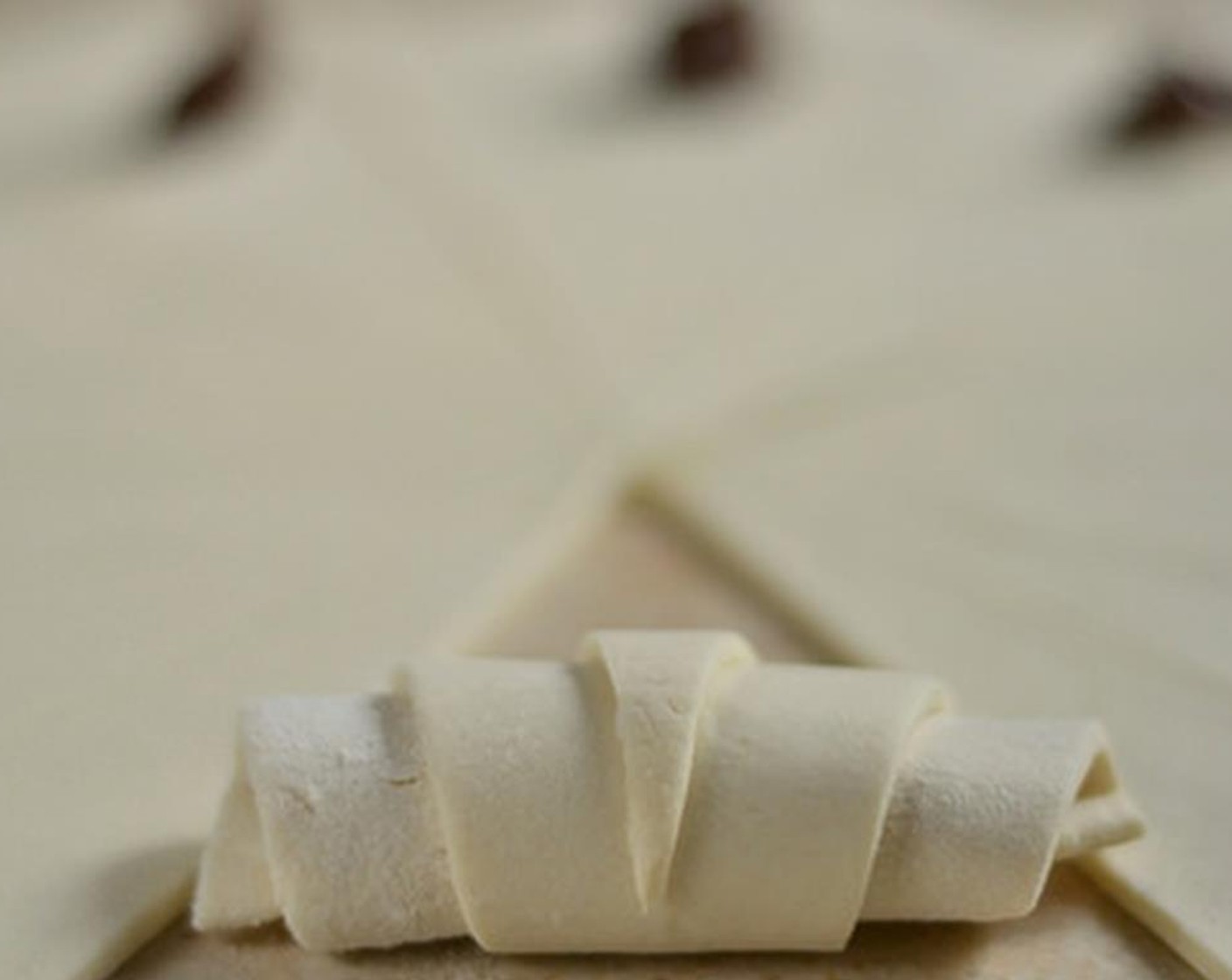 step 5 Roll triangle into croissant shape, making sure to seal the edges well so chocolate doesn't ooze out during baking.