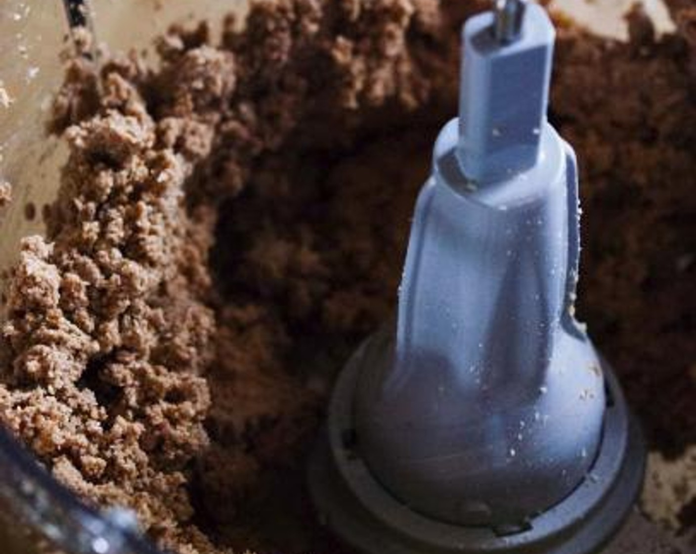 step 1 In a food processor, place together the Almonds (2/3 cup), Chocolate Hazelnut Spread (1/3 cup), Unsweetened Coconut Flakes (1/2 cup), Dates (3), Chocolate Plant-Based Protein Powder (1 scoop), Coconut Oil (1 Tbsp), and Chia Seeds (1 Tbsp).