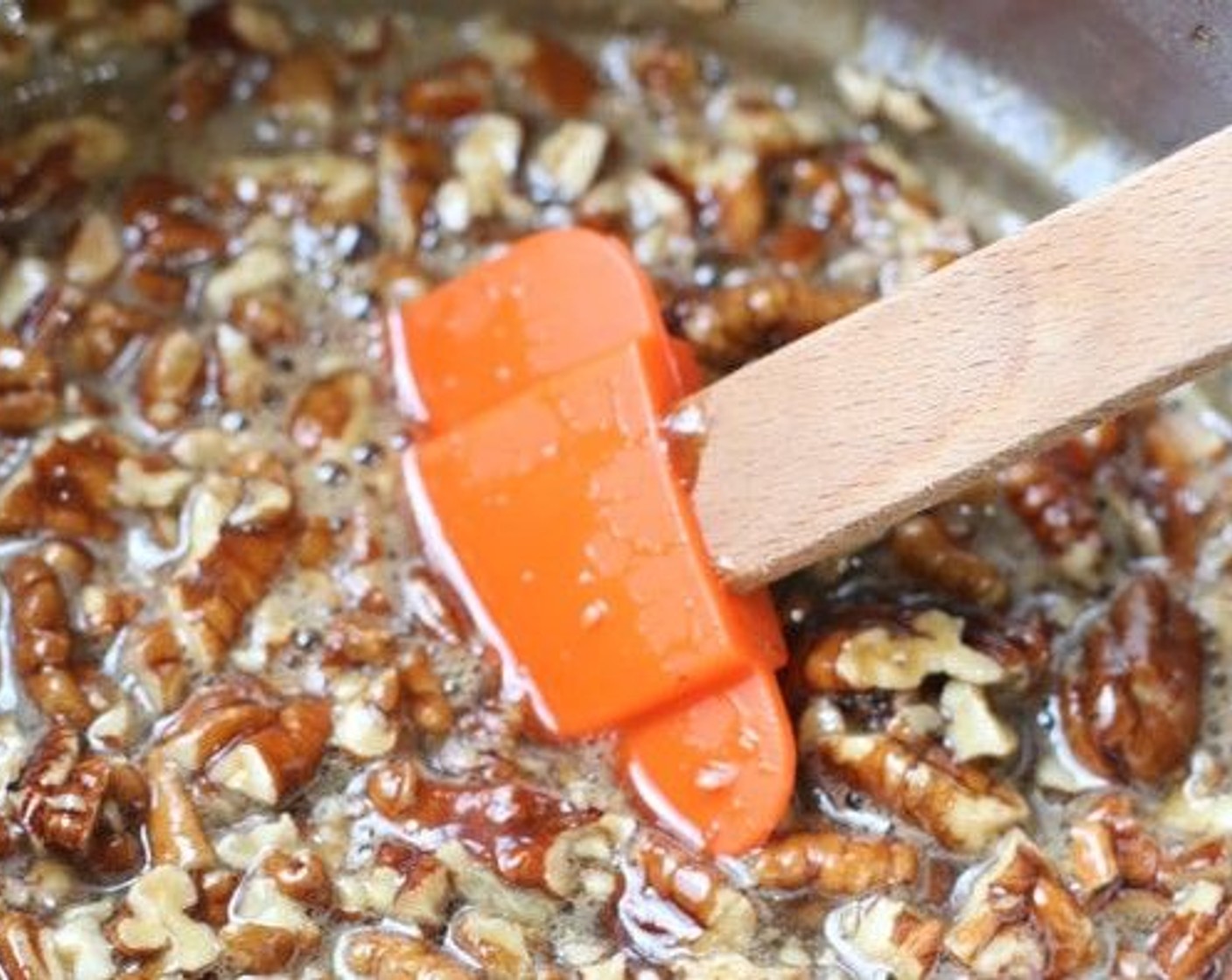 step 20 Return the bowl to hot simmering water; continue heating and stir until the mixture is shiny and hot to the touch, about 130 degrees F (55 degrees C) on an instant-read thermometer. Remove from the heat; stir in the toasted pecans.