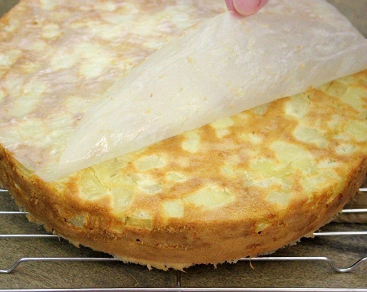 step 10 Run an offset spatula or butter knife around the edges of the cake pan. Flip the cake over onto a cooling rack. The parchment paper will peel right off.