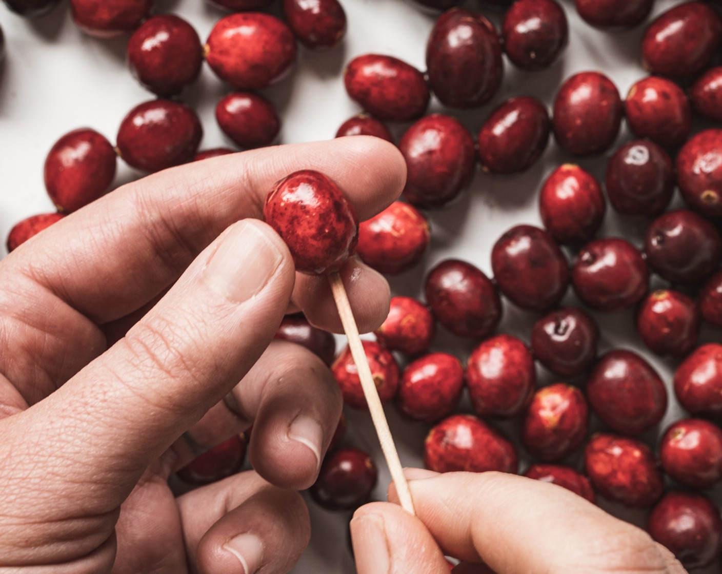 step 2 Slice any especially large cranberries in half and prick the rest with a toothpick, adding each prepared cranberry to a bowl to keep them sorted.