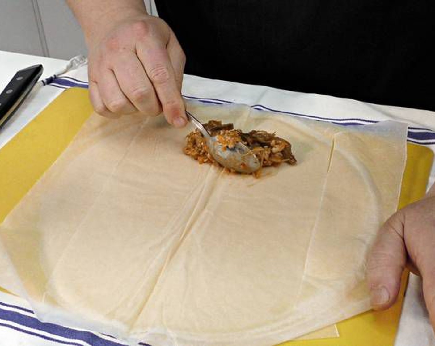 step 12 Lay out the Spring Roll Wrappers (8 sheets) and add one or two spoonfuls of the chicken mixture in the bottom center.