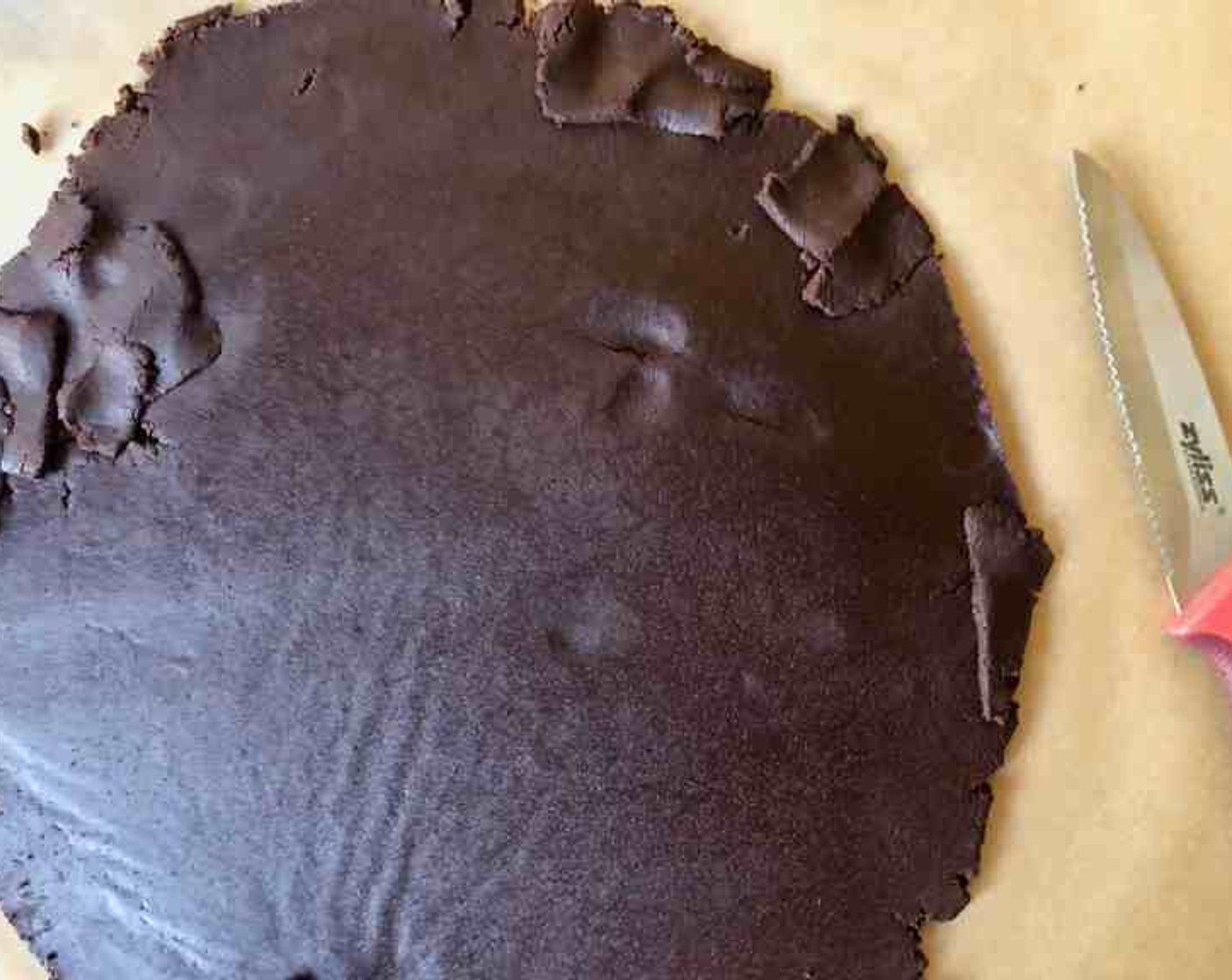 step 8 Carefully peel away top sheets of parchment from the dough and punch out cookies with larger cutters. Punch out centers of half of the cookies with smaller cutters.