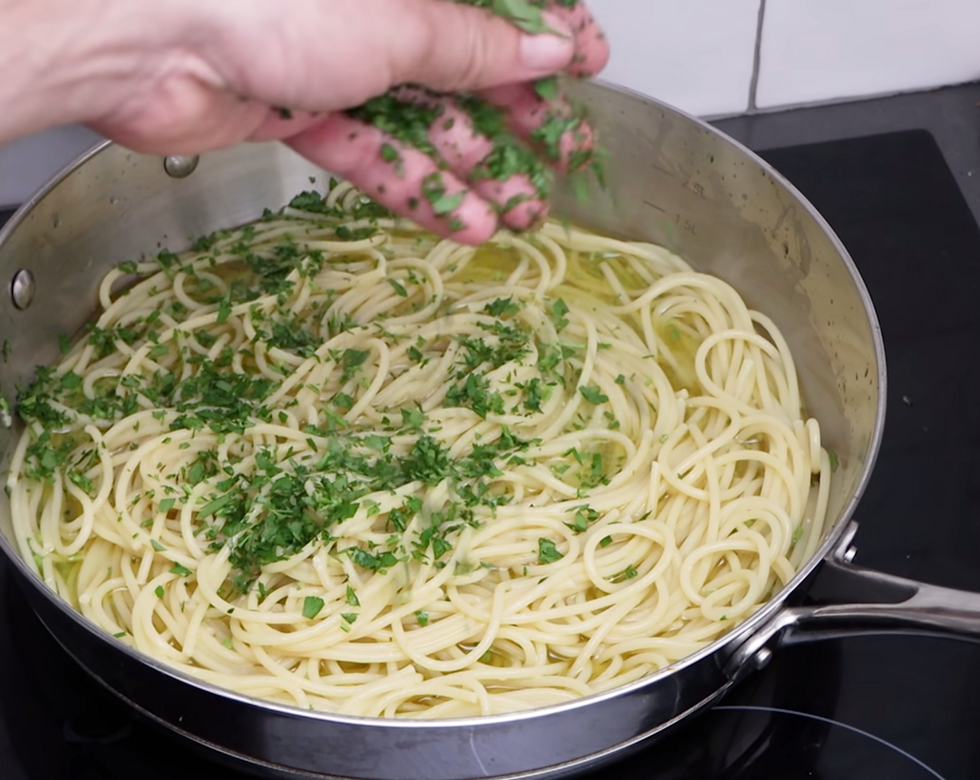 step 7 Mix the pasta through the oil really well, before sprinkling a very generous amount of the chopped parsley into the pan and mixing again.