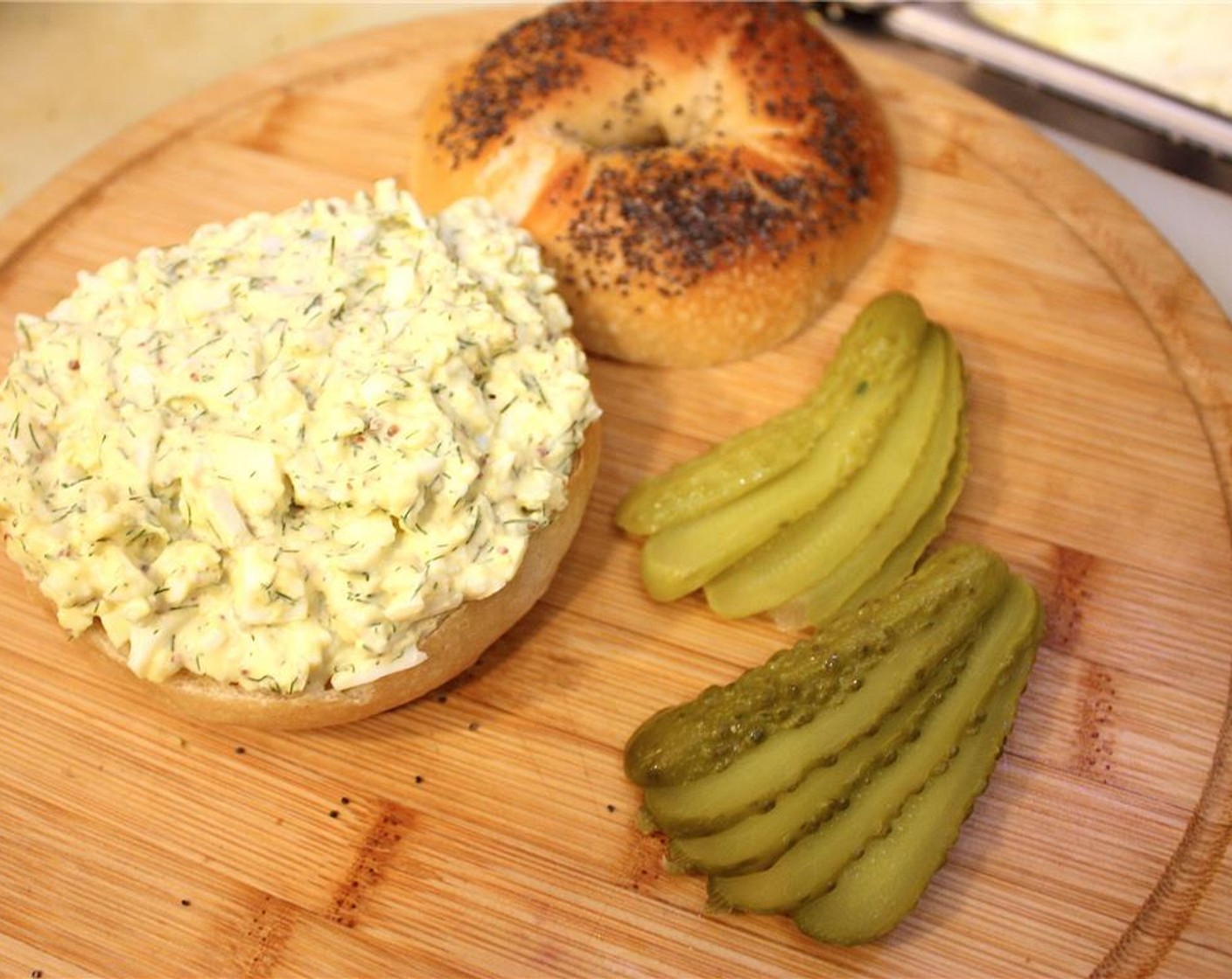step 9 Spread the egg salad onto the open face of the bagel. Slice Pickles (2) and place on top of the egg salad.