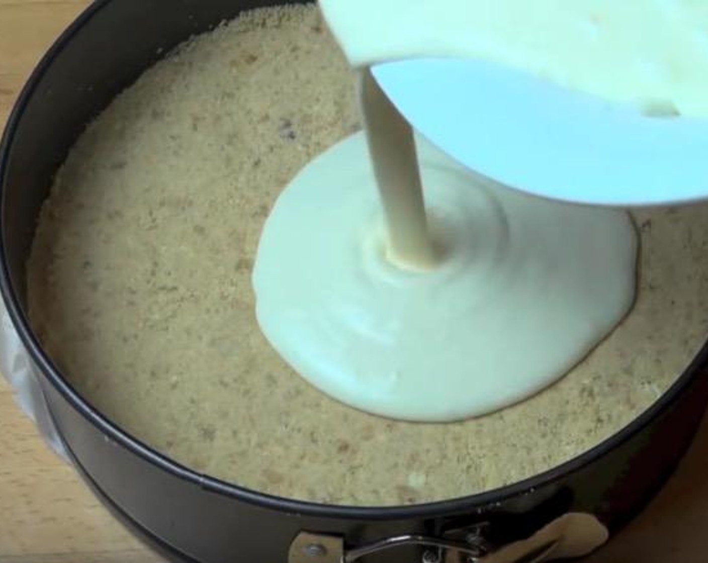 step 6 Pour the cheesecake mixture over the biscuit base. Gently tap the pan against a table to release air bubbles.