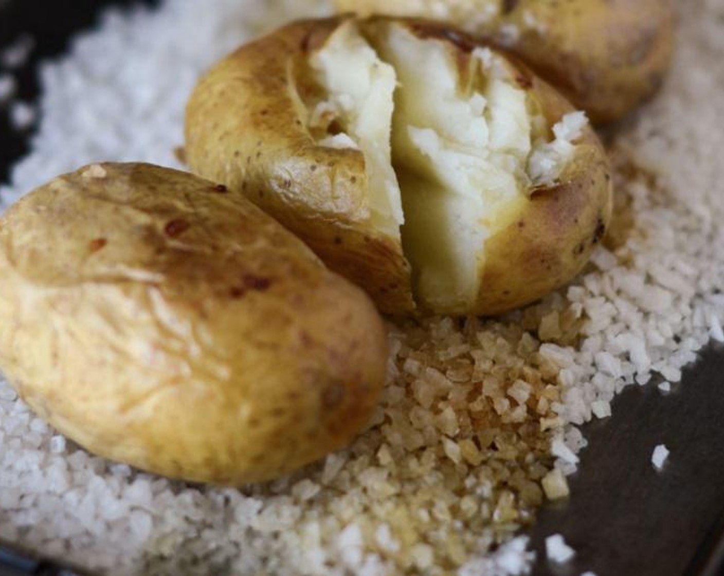 step 2 Using a sharp knife, prick the Maris Piper Potatoes (4) all over and rub with a little Olive Oil (as needed). Place on top of the Rock Salt (1 cup) and bake in the oven for an hour or until tender. Leave to cool while you make the sauce.