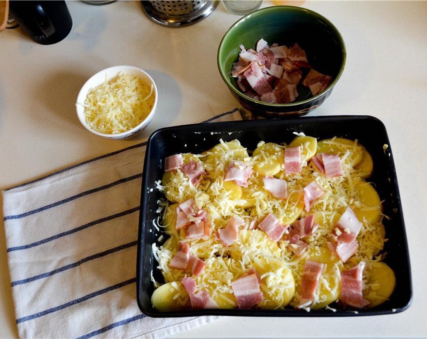 step 6 Spread half of the chopped potato at the bottom of the tray. Then, cover the potatos with half of the cheese and half of the bacon. Add another layer of potato followed by the remaining cheese and bacon.