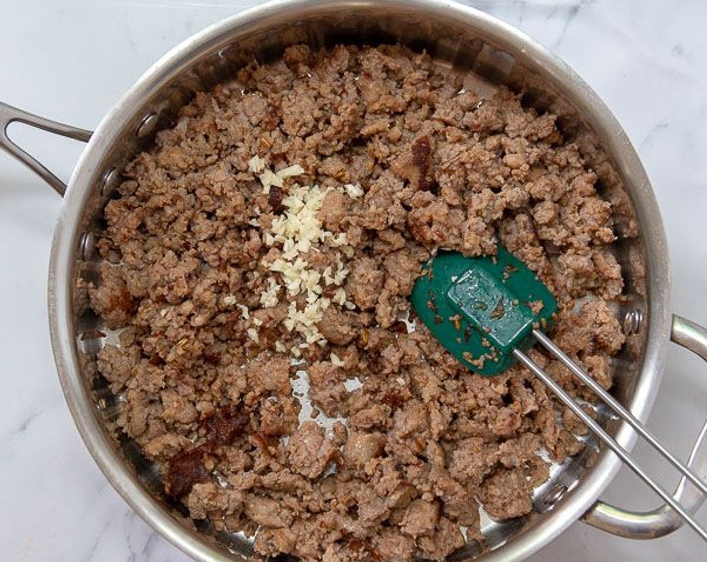 step 2 Meanwhile heat a large deep skillet over medium high heat. Remove casings from Sweet Italian Sausage Link (1 pckg) and brown, breaking it up into smaller pieces as it cooks. Once sausage is browned and no longer pink, add Garlic (2 cloves) and cook for 30 seconds longer.