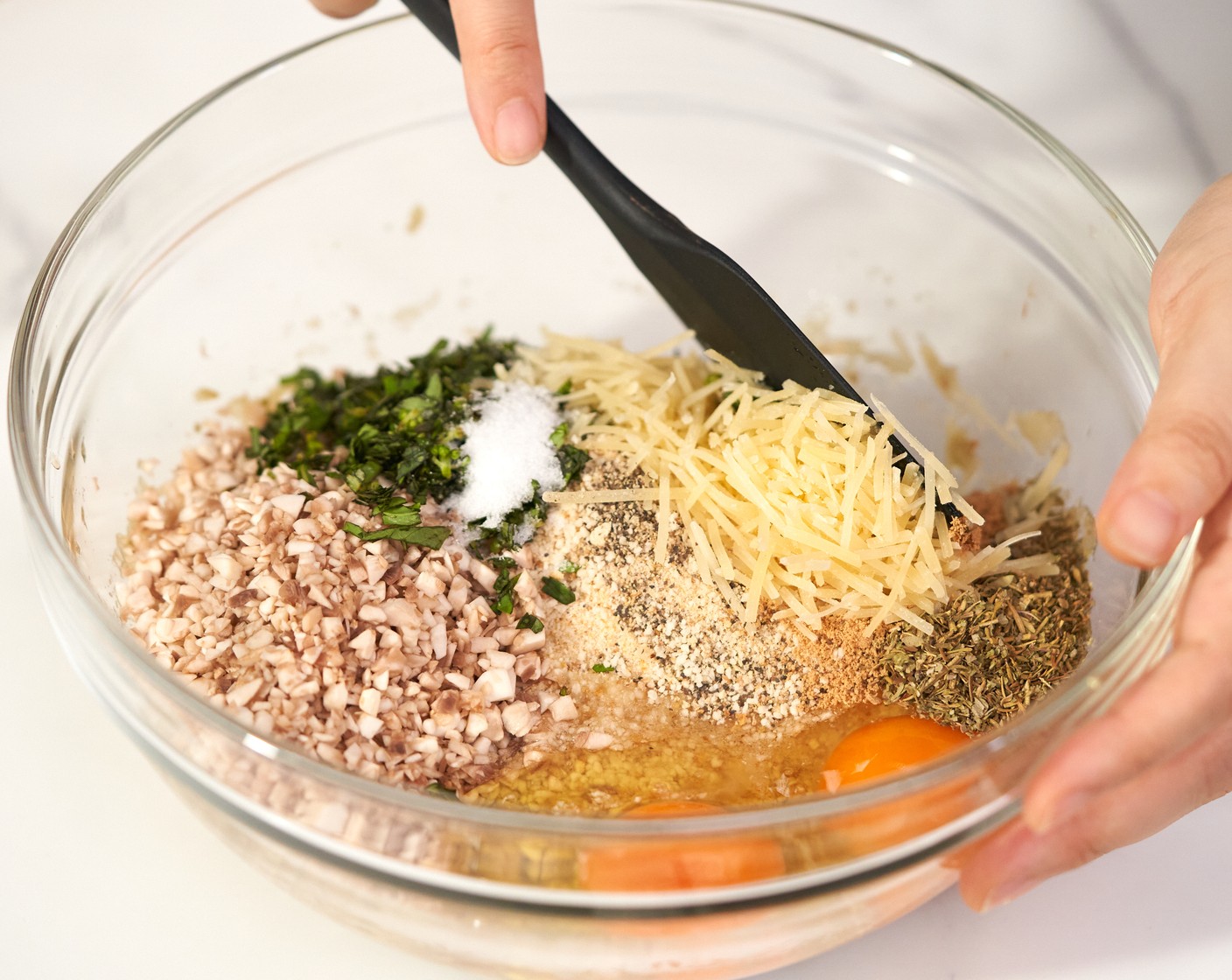 step 6 In the bowl of the eggplant mixture, add Breadcrumbs (1 cup), Button Mushroom (1/2 cup), Eggs (2), Fresh Basil (2 Tbsp), Italian Seasoning (1 Tbsp), Onion Powder (1 tsp), Parmesan Cheese (1/4 cup), Salt (1/2 tsp), and Ground Black Pepper (1/4 tsp). Mix everything until well combined.