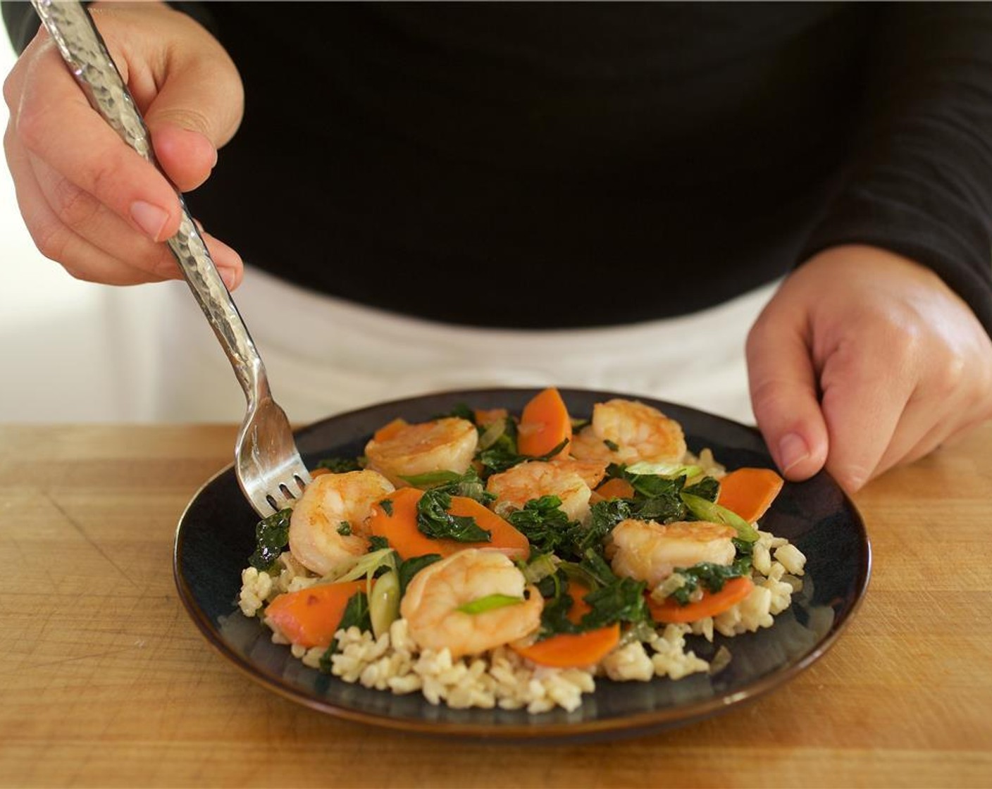 step 9 Place rice in the center of two plates. Add shrimp stir fry on top of the rice.