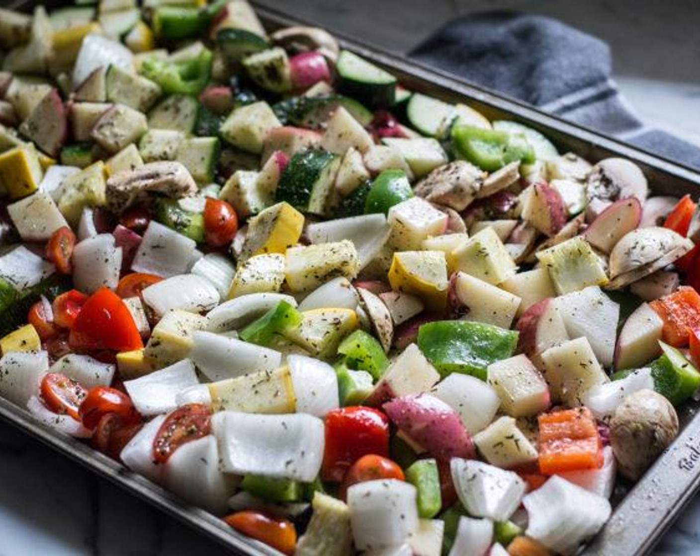 step 4 Mix to combine, then drop spoonfuls of seasoned oil over prepped veggies on both baking sheets, use hands to toss and coat.