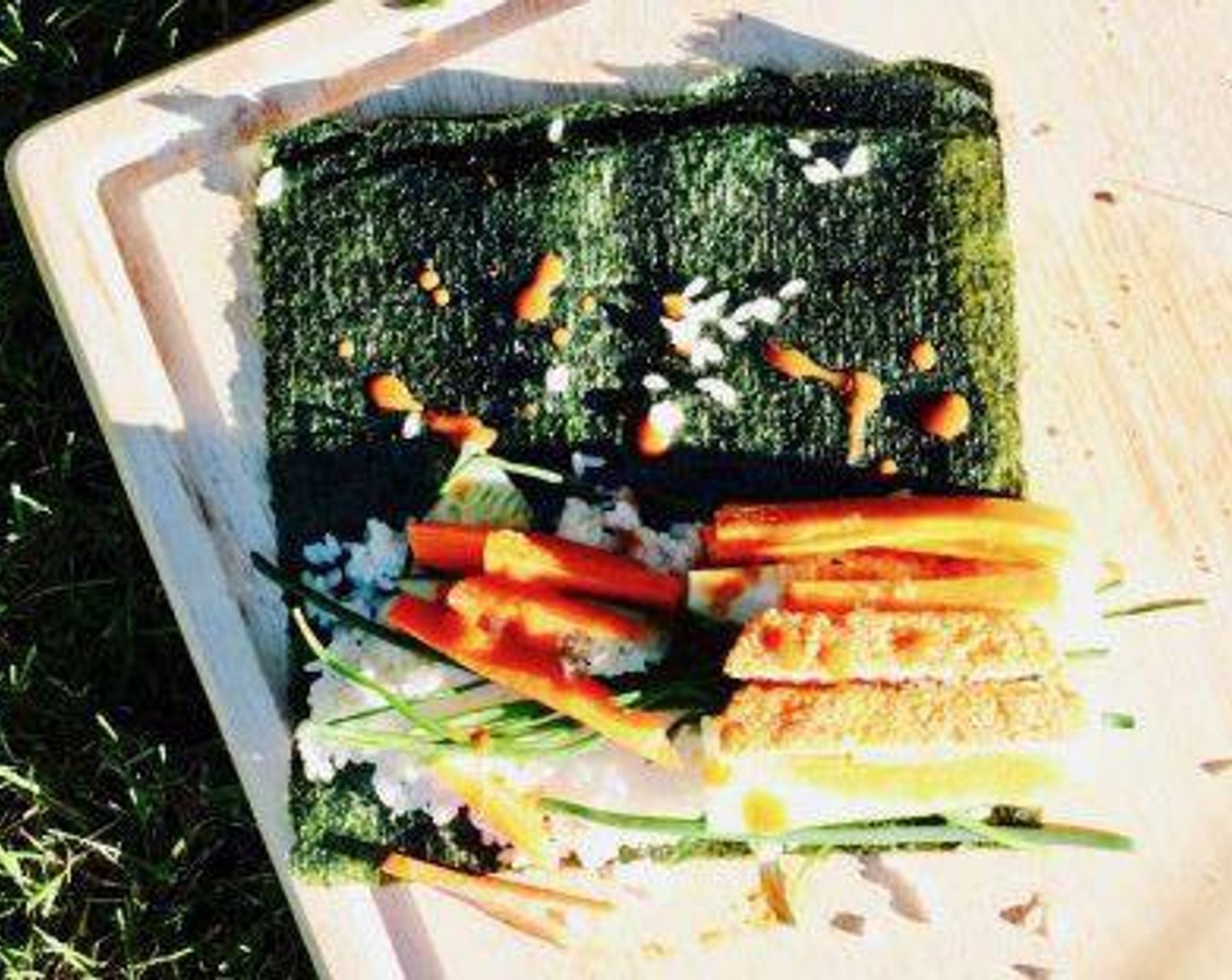step 5 Split the cooked Short Grain White Rice (4 Tbsp) into 4 portions and top half of each Nori Sheets (4) with rice. Add Hot Sauce (to taste) on each roll. Divide and add pinto beans, vegan patty, vegan cheese, carrot, and cucumber to each. If using, add sliced Avocados (to taste) and Fresh Cilantro (to taste). Finally, add the Fresh Chives (1 handful).