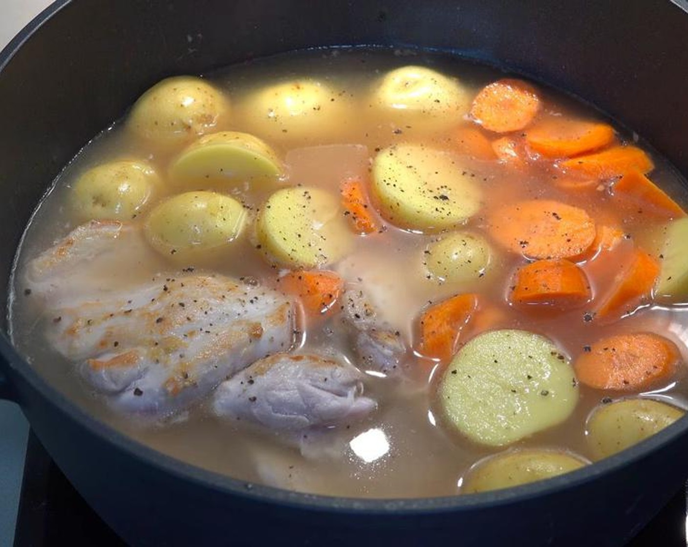 step 3 Add the chicken back to the pot, along with the Carrots (3), Baby Potatoes (8), and Chicken Stock (4 cups). Season with Freshly Ground Black Pepper (to taste).