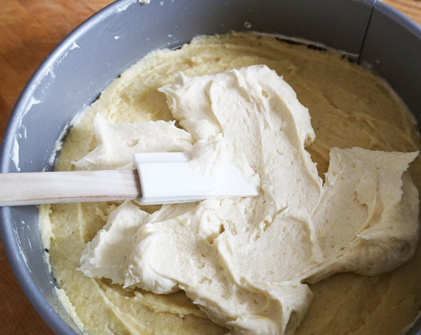 step 7 Spoon about half the cake batter into the prepared pan and spread it into an even layer. Place small spoonfuls of the frangipane on top, covering as much of the cake as possible, then gently spread the frangipane with a spatula to cover the entire surface of the cake.