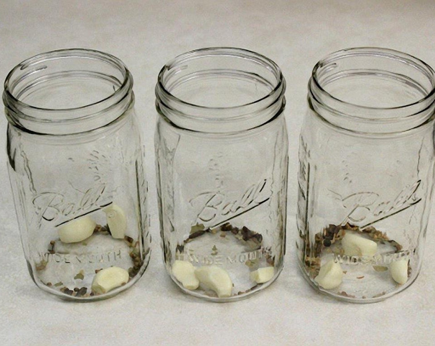 step 3 In 3 clean jars (1 quart each), add 2-3 peeled Garlic (9 cloves) and Pickling Spice (1 1/2 Tbsp) (optional) to each.