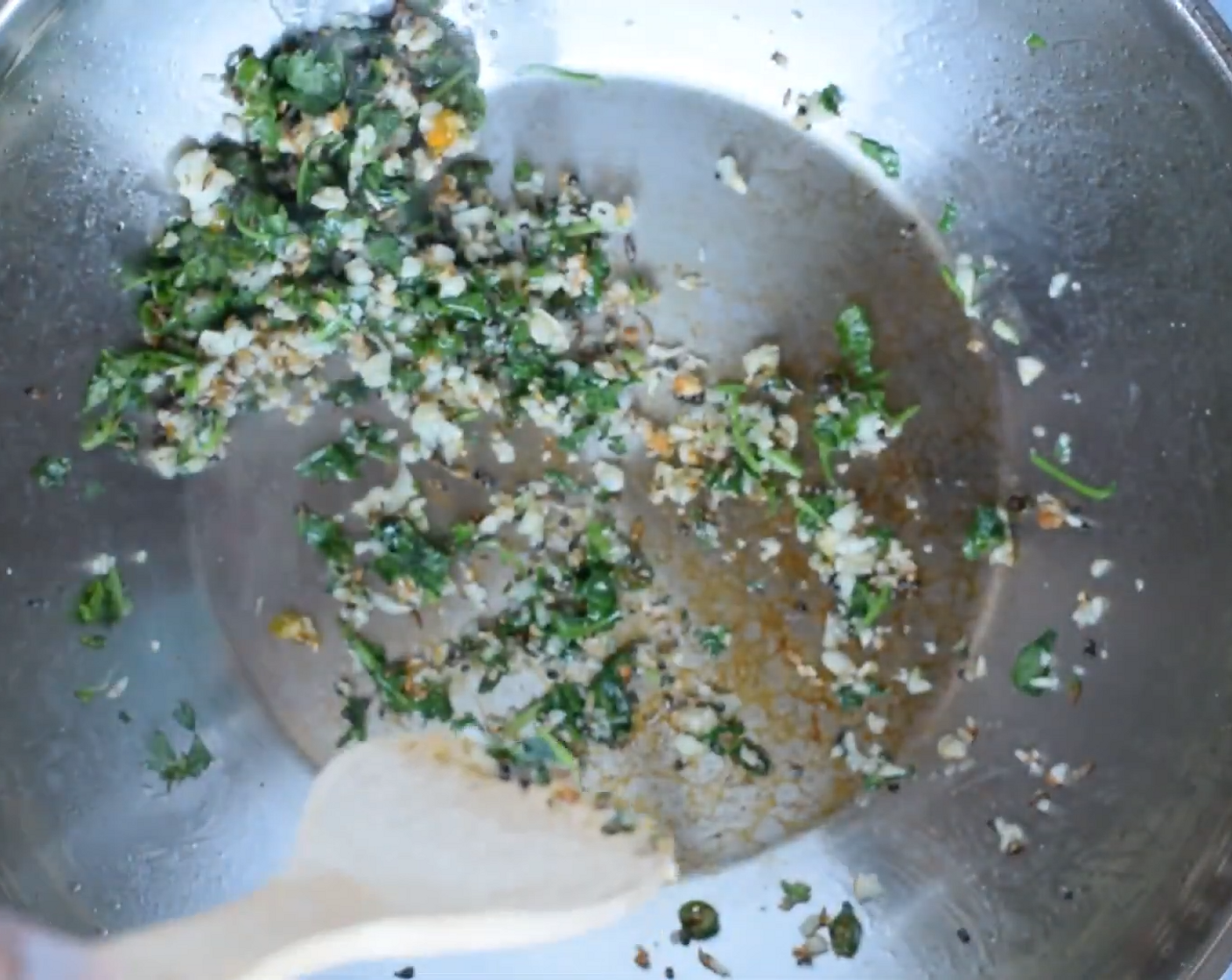 step 2 As they begin to crackle, add Curry Leaves (5), Garlic (8 cloves), Ginger Paste (1 Tbsp), and part of Fresh Cilantro (2 Tbsp).